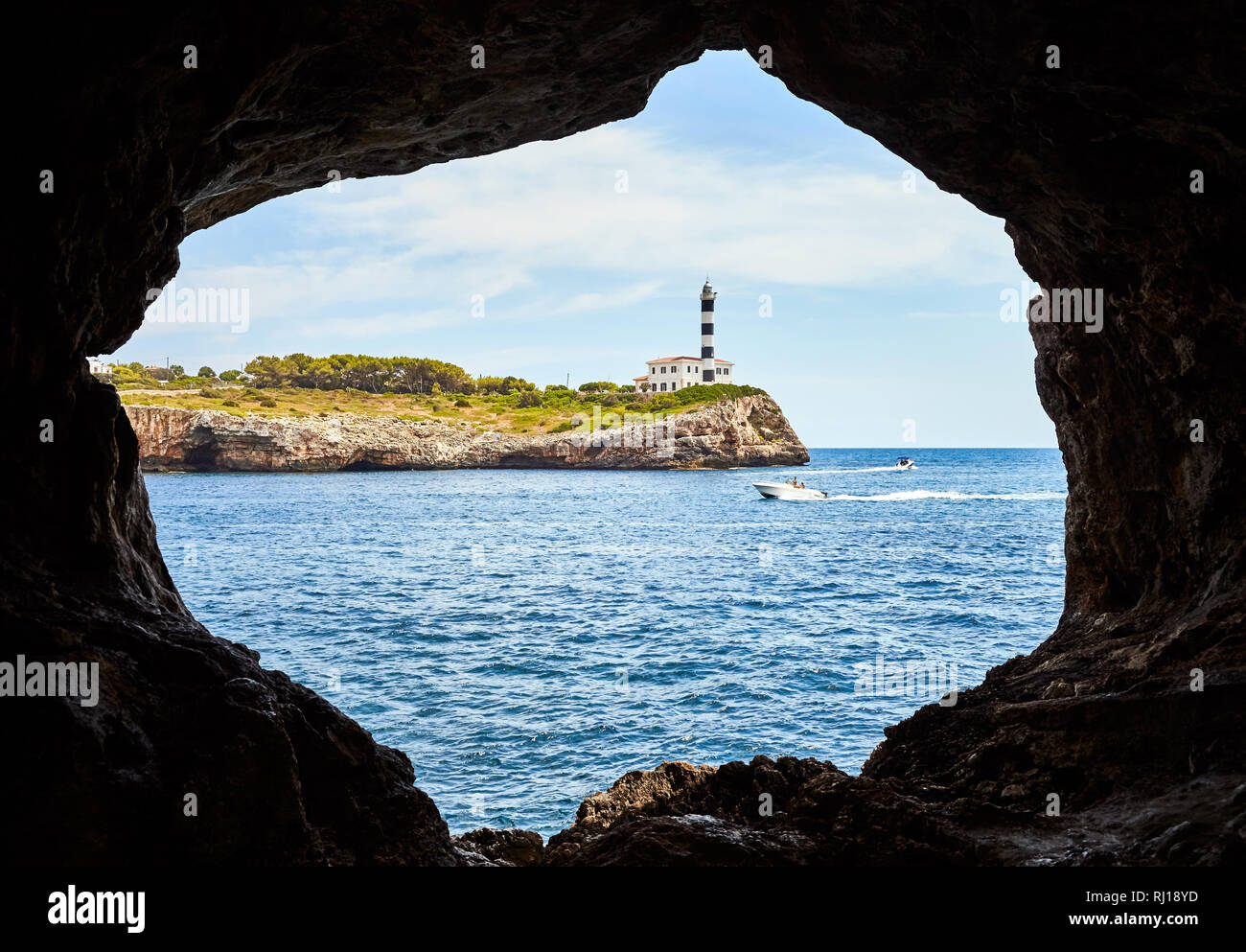 Portocolom Leuchtturm aus einer Höhle, Mallorca, Spanien gesehen. Stockfoto