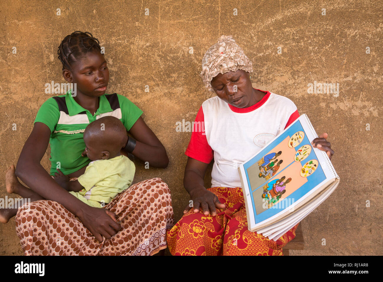 Samba Dorf, yako Provinz, Burkina Faso: Abzetta Sondo, 19, und Ihr Kind leidet an akuter Unterernährung, get Anweisung von Helene Pagoundba, Ernährung Bildung Mitglied des Ausschusses. Stockfoto