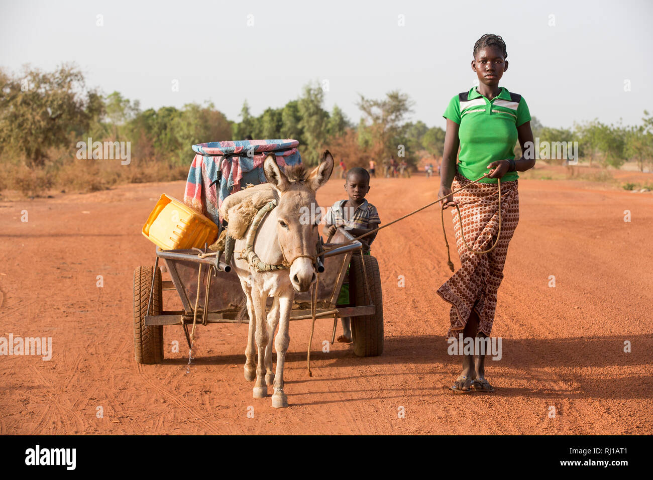 Samba Dorf, yako Provinz, Burkina Faso: Abzetta Sondo, 19, kehrt mit vollen Wasserbehälter aus dem gut für Ihr Haus. Stockfoto