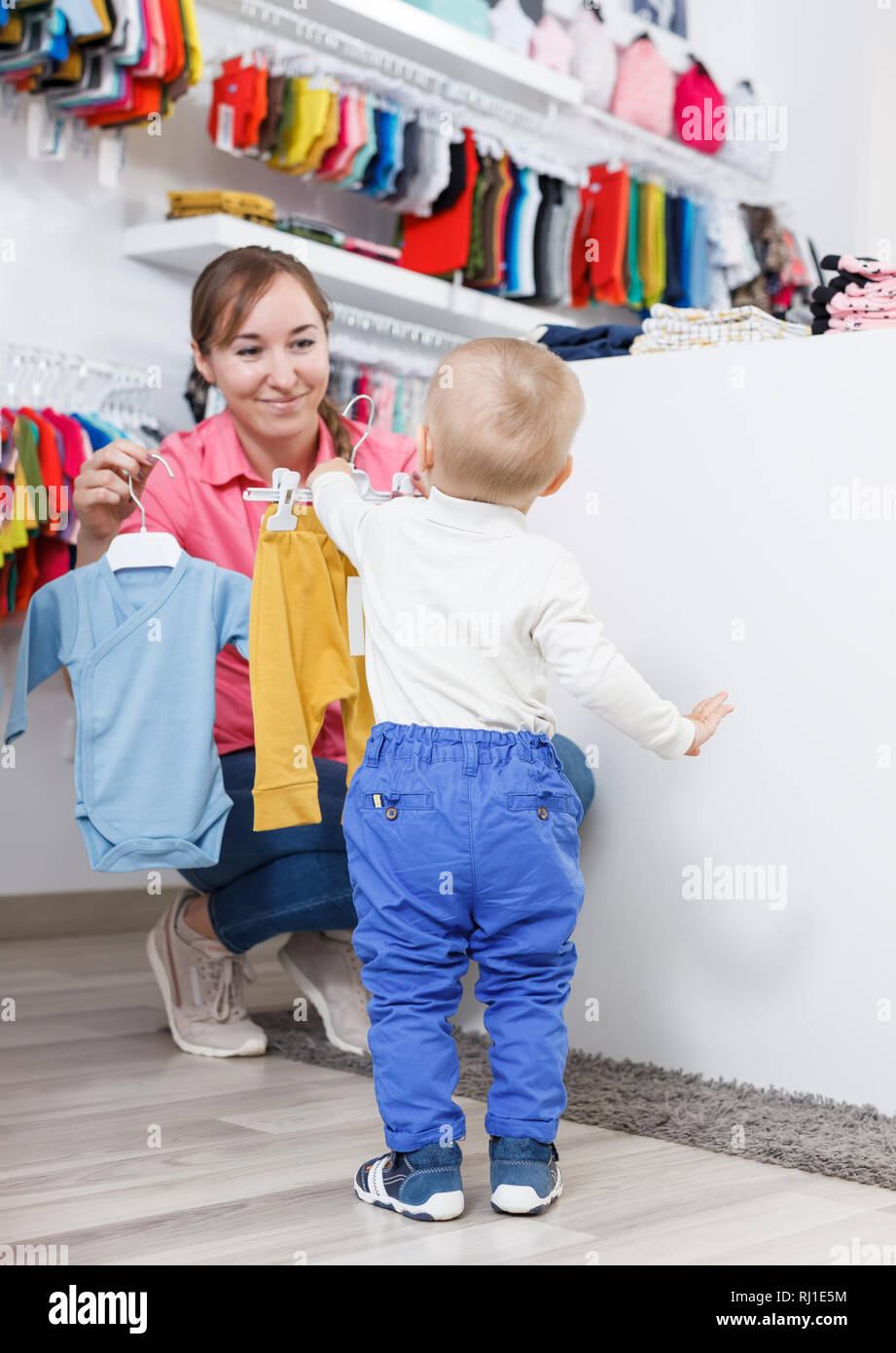 Lächelnd Mama mit Kind sucht moderne Kleidung für den kleinen Sohn im Store  Stockfotografie - Alamy