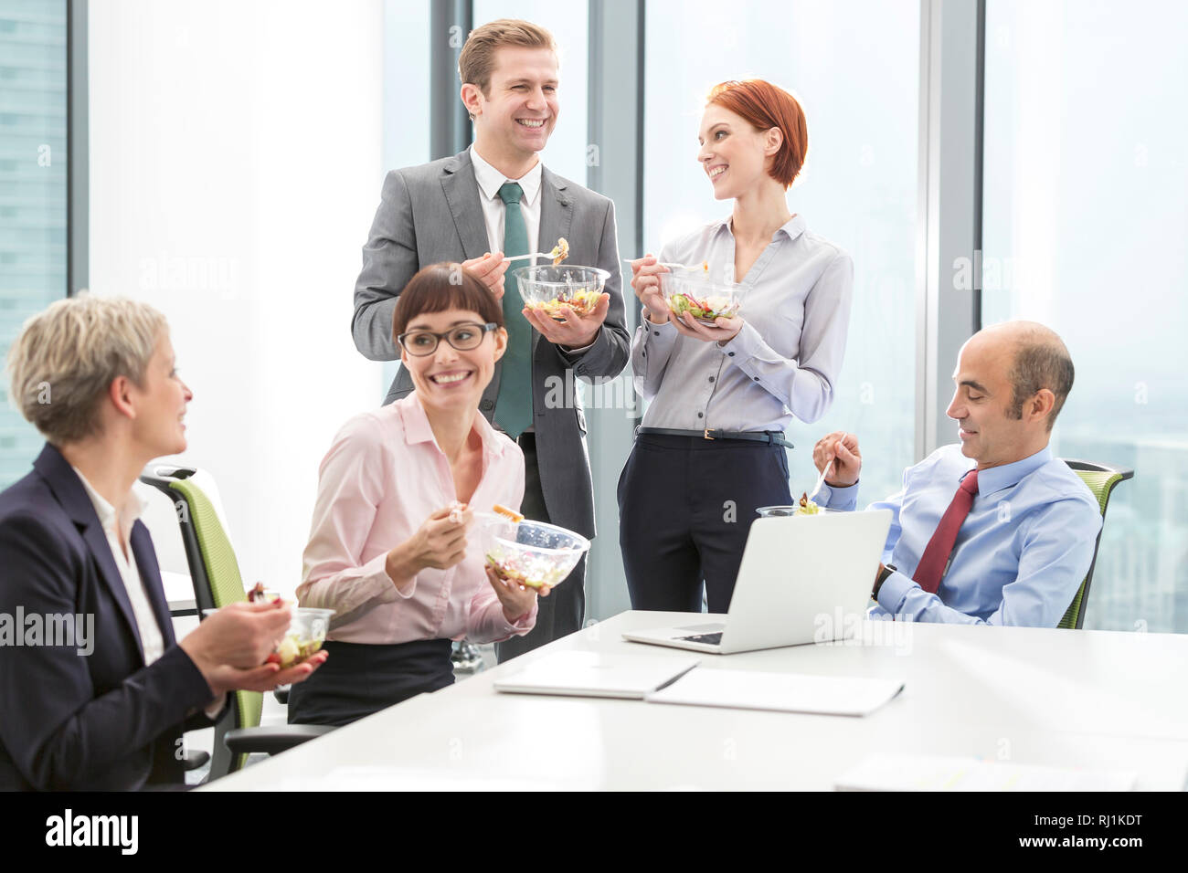 Lächelnd Kollegen das Mittagessen im Sitzungssaal während der Sitzung im Büro Stockfoto