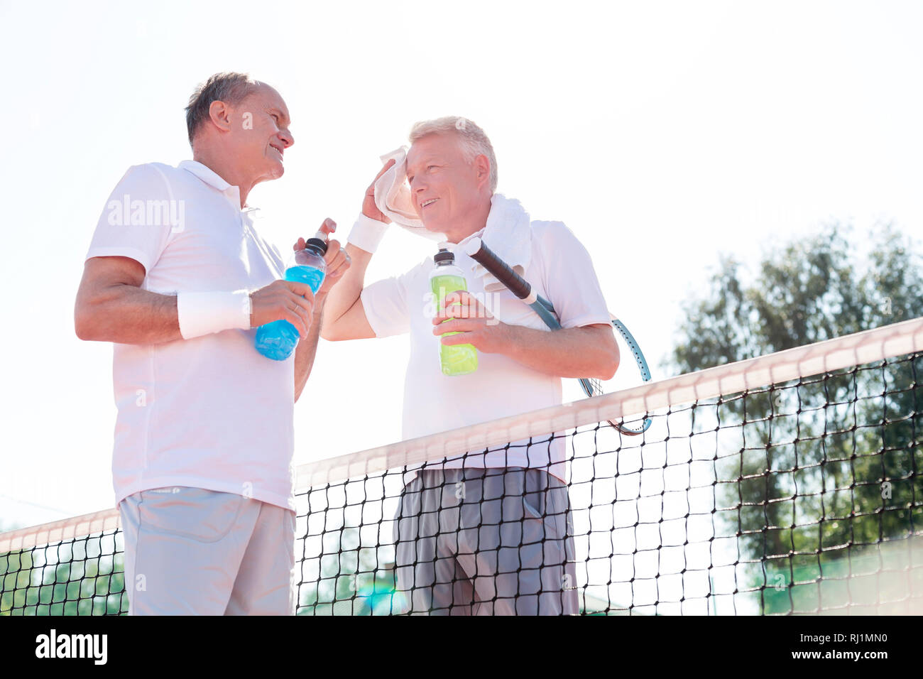 Low Angle View der Männer, während Sie von Tennis Netz gegen klaren Himmel stehen an einem sonnigen Tag Stockfoto