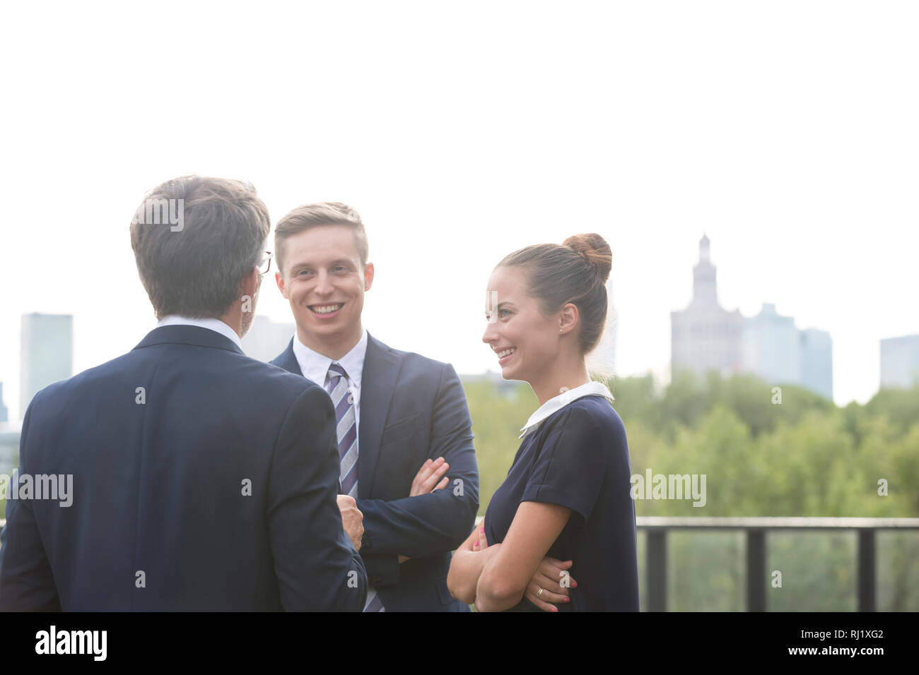 Lächelnd Kollegen diskutieren beim Stehen in der Stadt Stockfoto