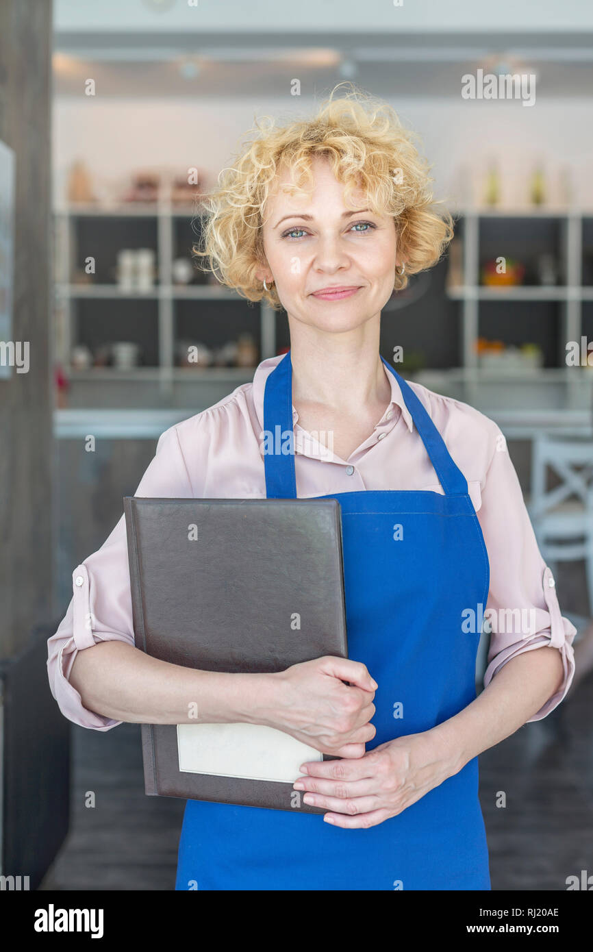 Portrait von zuversichtlich reife Kellnerin Holding im Restaurant Stockfoto