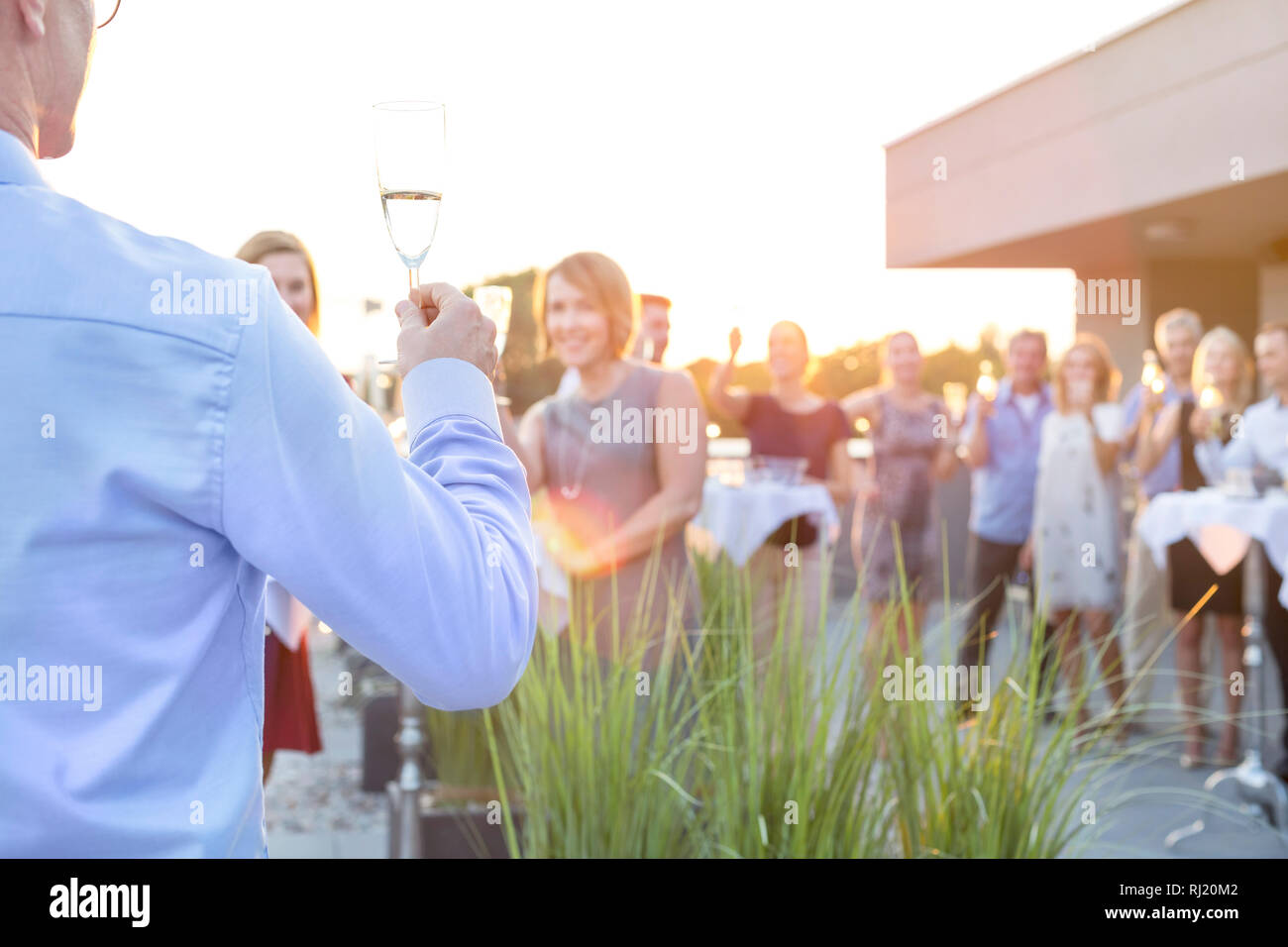 Reifen Geschäftsmann toasten wineglass mit Kollegen während Erfolg Party auf dem Dach Stockfoto