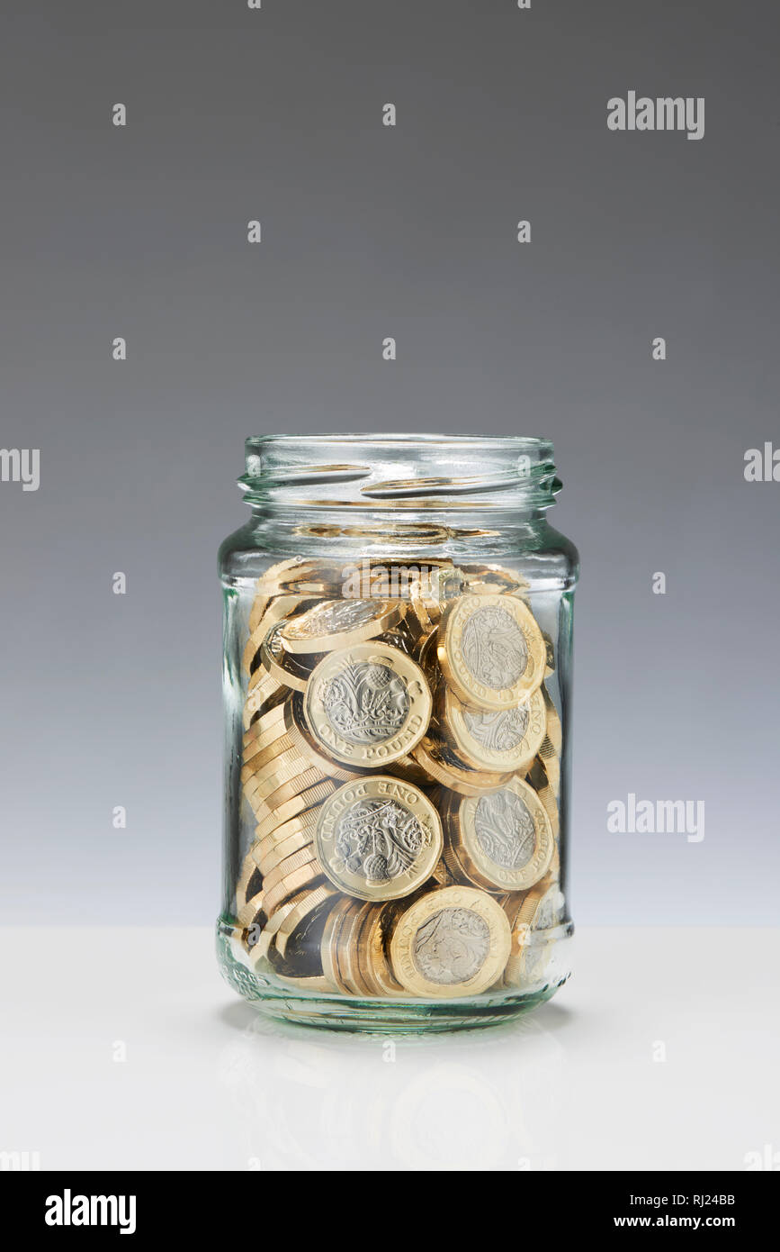 Einsparungen aus Glas Glas mit einem Pfund Münzen Stockfoto