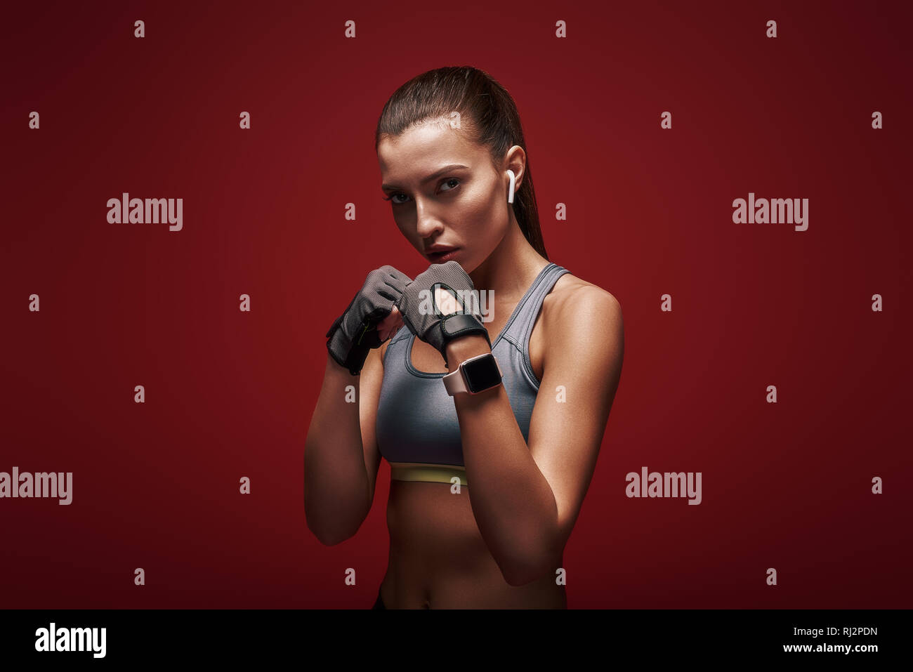 Porträt der jungen schönen Sportlerin workout Handschuhe tragen. Sie ist bereit, zu kämpfen. Über den roten Hintergrund isoliert Stockfoto