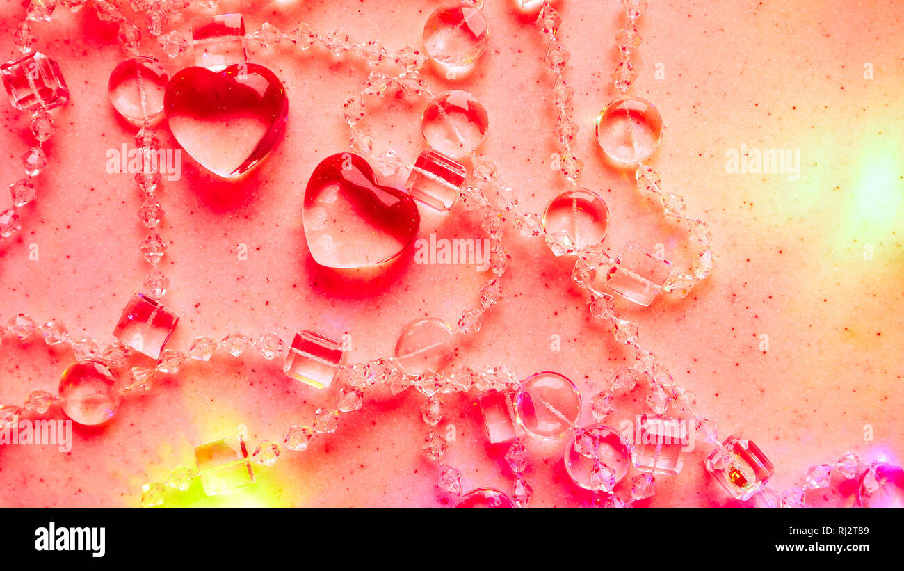 Transparente Herzen und Perlen auf Marmor in rosa Ton. Perfekte Valentinstag Grußkarte Hintergrund. Stockfoto