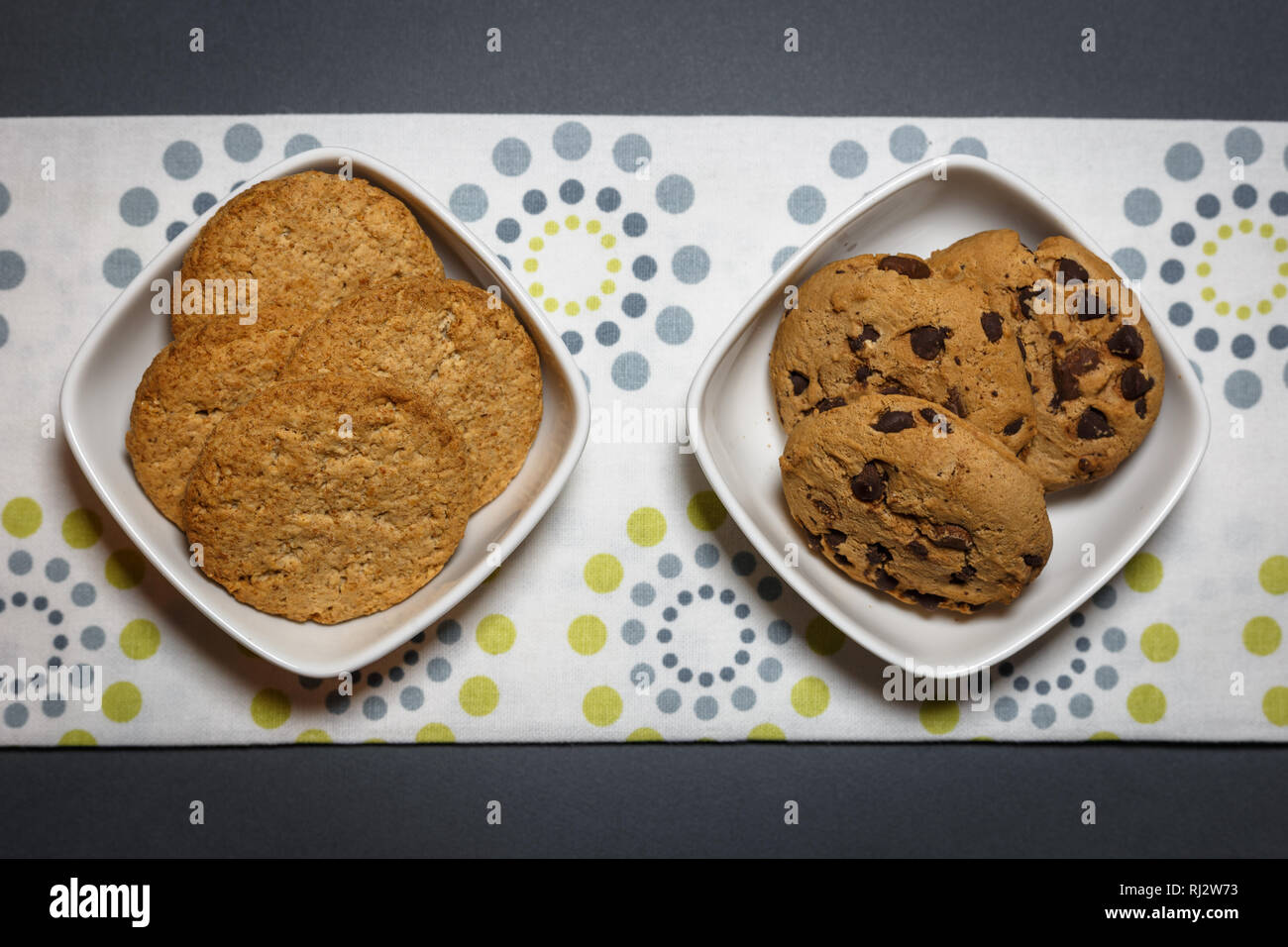 Zwei verschiedene Arten von Cookies, Haferflocken und Chocolate Chip Cookies in den weißen Schalen. Ansicht von oben flach Hintergrund. Stockfoto