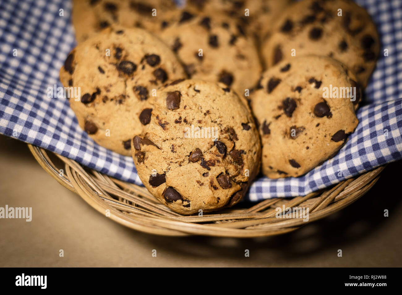 Chocolate Chips Cookies in einem Holz- Korb. Essen Fotografie Thema in Vintage oder retro farbe Stil. Stockfoto