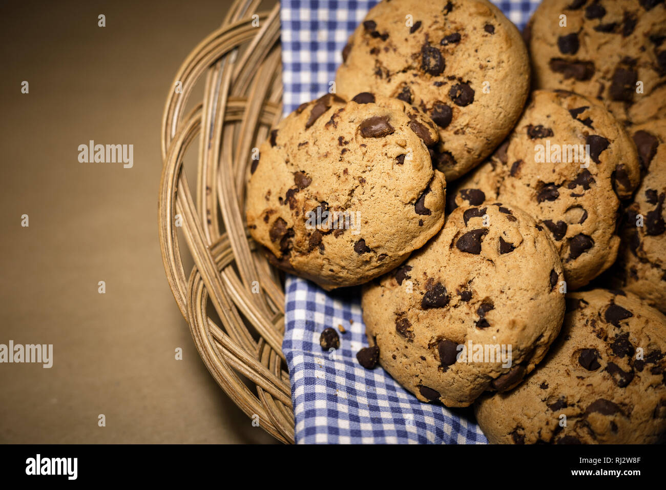 Chocolate Chips Cookies in einem Holz- Korb. Essen Fotografie Thema in Vintage oder retro farbe Stil. Stockfoto