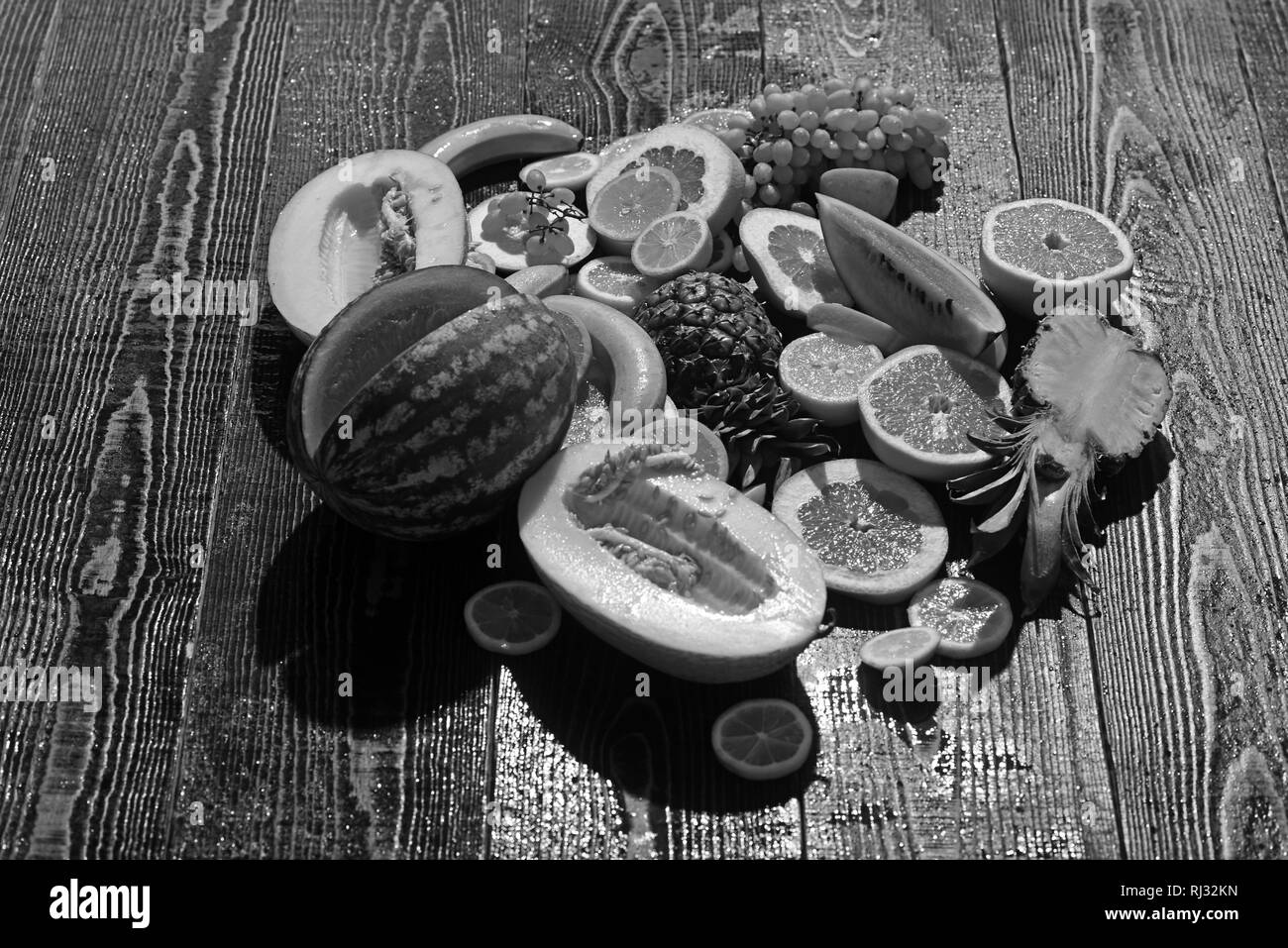 Frische Früchte der Wassermelone Melone und Banane auf Holztisch. orange Ananas Zitrone mit Grapefruit und Trauben Layout. Vitamin Ernährung und Gesundheit Stockfoto