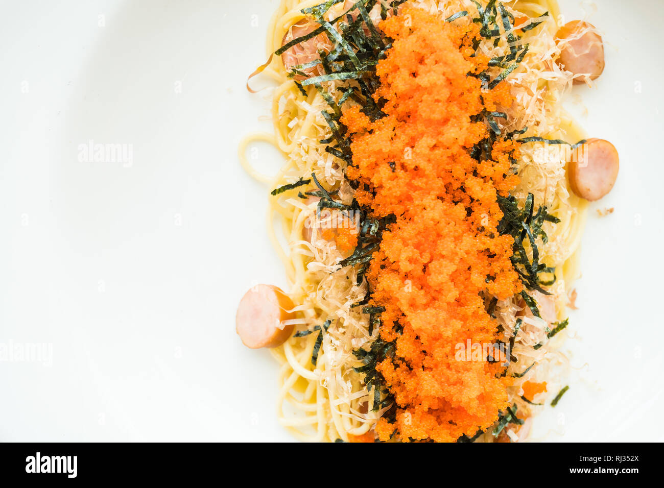 Spaghetti mit Wurst, Garnelen, Algen, Eier und trocken Squid auf die Oberseite in weißer Teller - italienische Speisen Stil Stockfoto