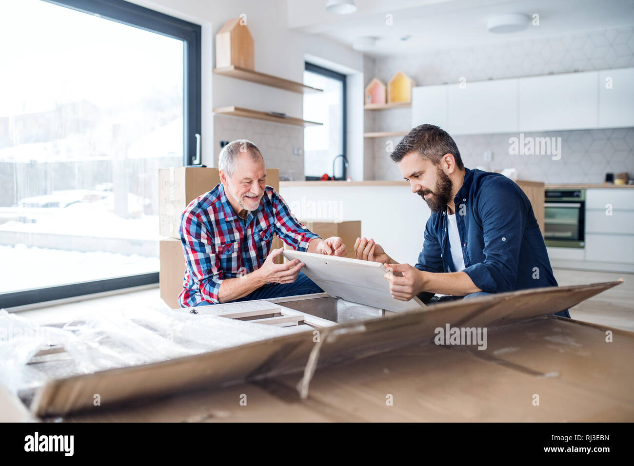 Ein reifer Mann mit seinem älteren Vater Zusammenbau von Möbeln, ein neues Zuhause. Stockfoto