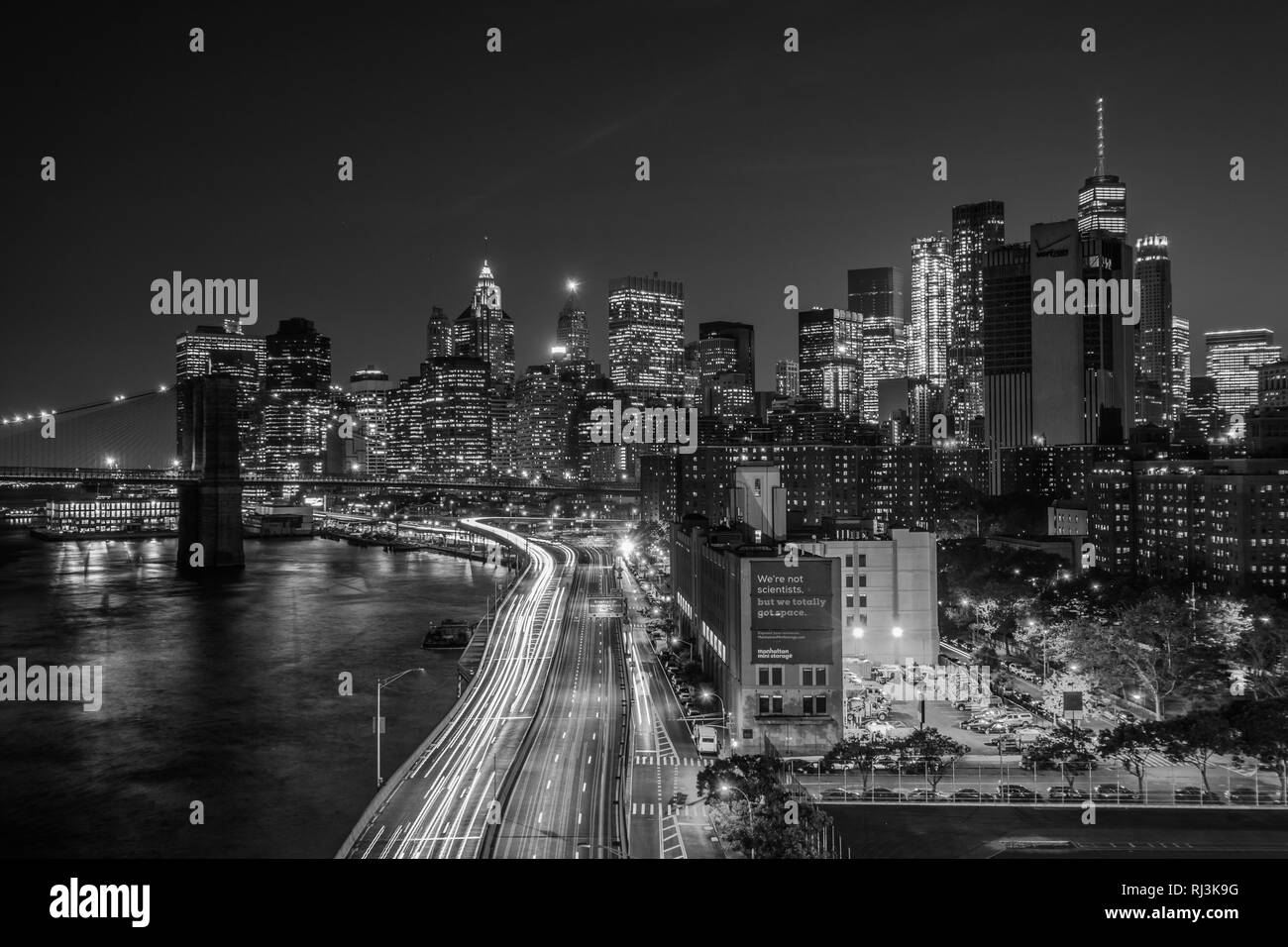 Blick auf den FDR Drive und der Lower Manhattan Skyline bei Nacht, von der Manhattan Bridge Walkway, New York. Stockfoto