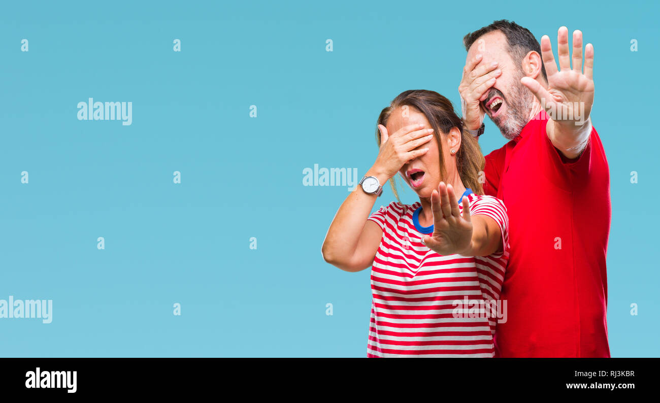 Mittleres Alter spanischer Paar in Liebe über isolierte Hintergrund die Augen mit der Hand und dem Tun stoppen Geste mit traurigen und Angst Ausdruck. Verlegen Stockfoto