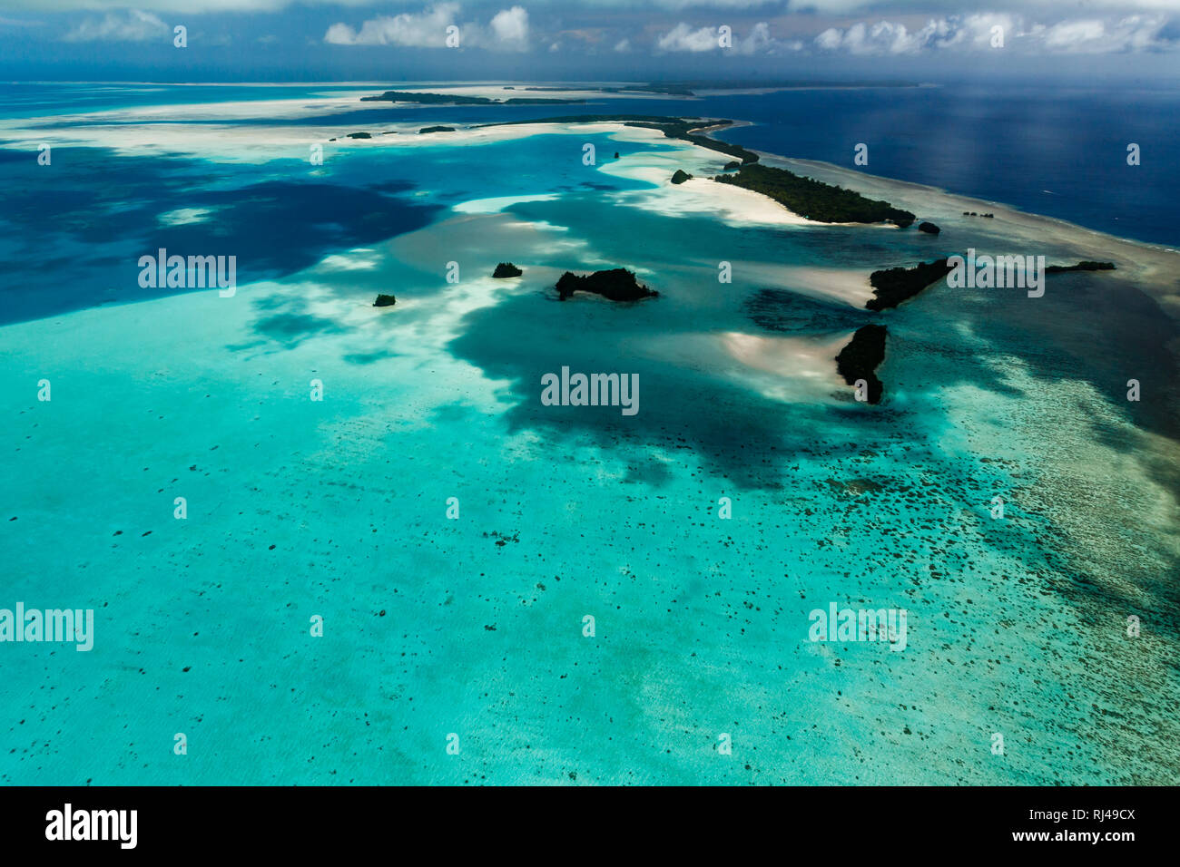 Luftaufnahme von langen schmalen Spektrum der Gruppe von Inseln umgeben von Korallenriffen in South Pacific Stockfoto