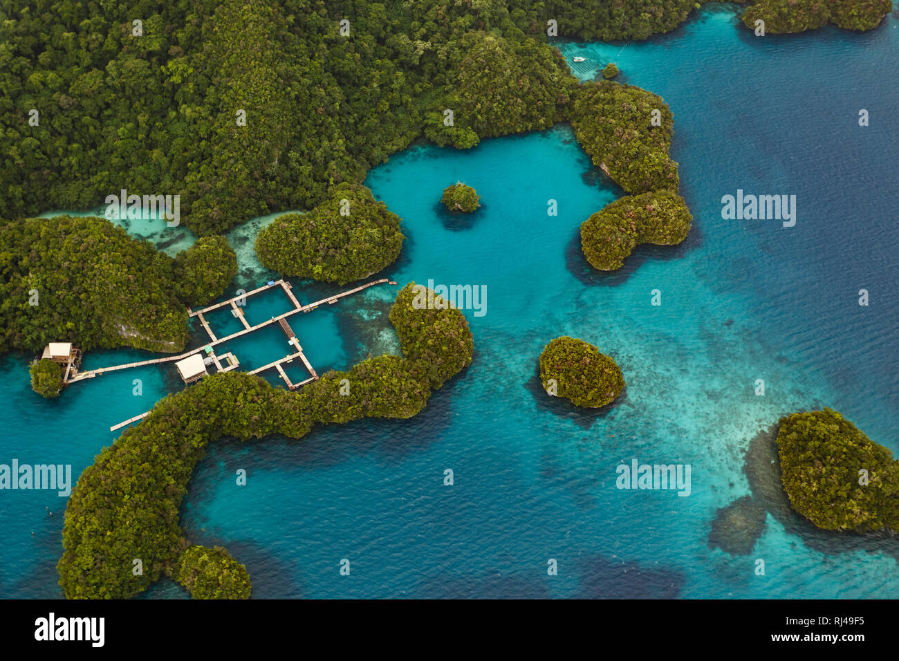 Luftaufnahme von Square Holz Docks in Gruppe von kleinen südpazifischen Inseln mit üppiger Vegetation und Korallenriffe in türkis Meer bedeckt Stockfoto