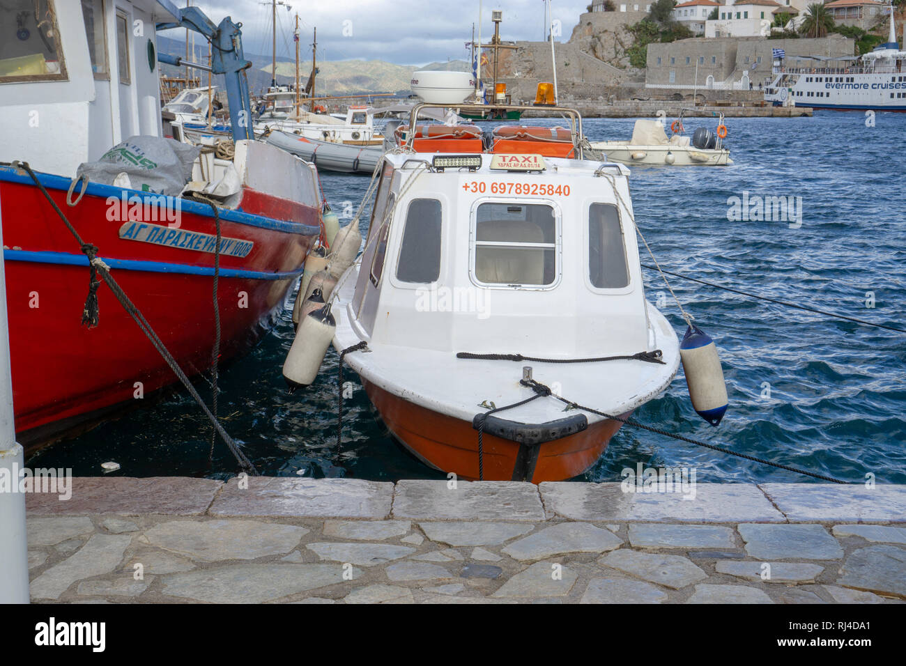 Autos sind auf der Insel Hydra erlaubt, aber es gibt viele Fischerboote und Yachten. Stockfoto