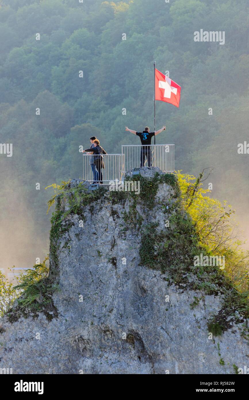 Vantage Point, rock mit Touristen am Rheinfall mit Schweizer Flagge, Schaffhausen, Schweiz Stockfoto