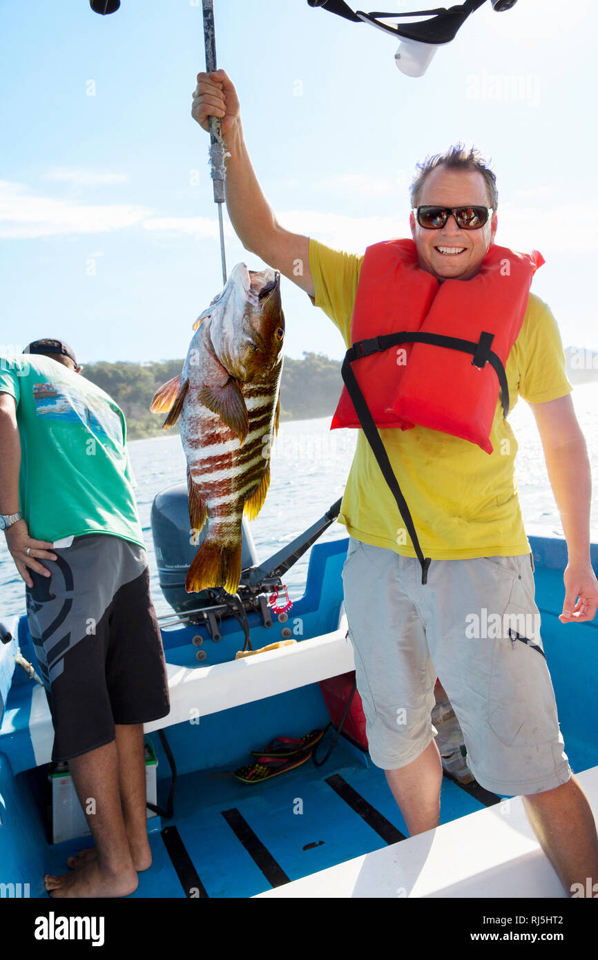 Stolz Mann mit Fisch auf Fischerboot Stockfoto