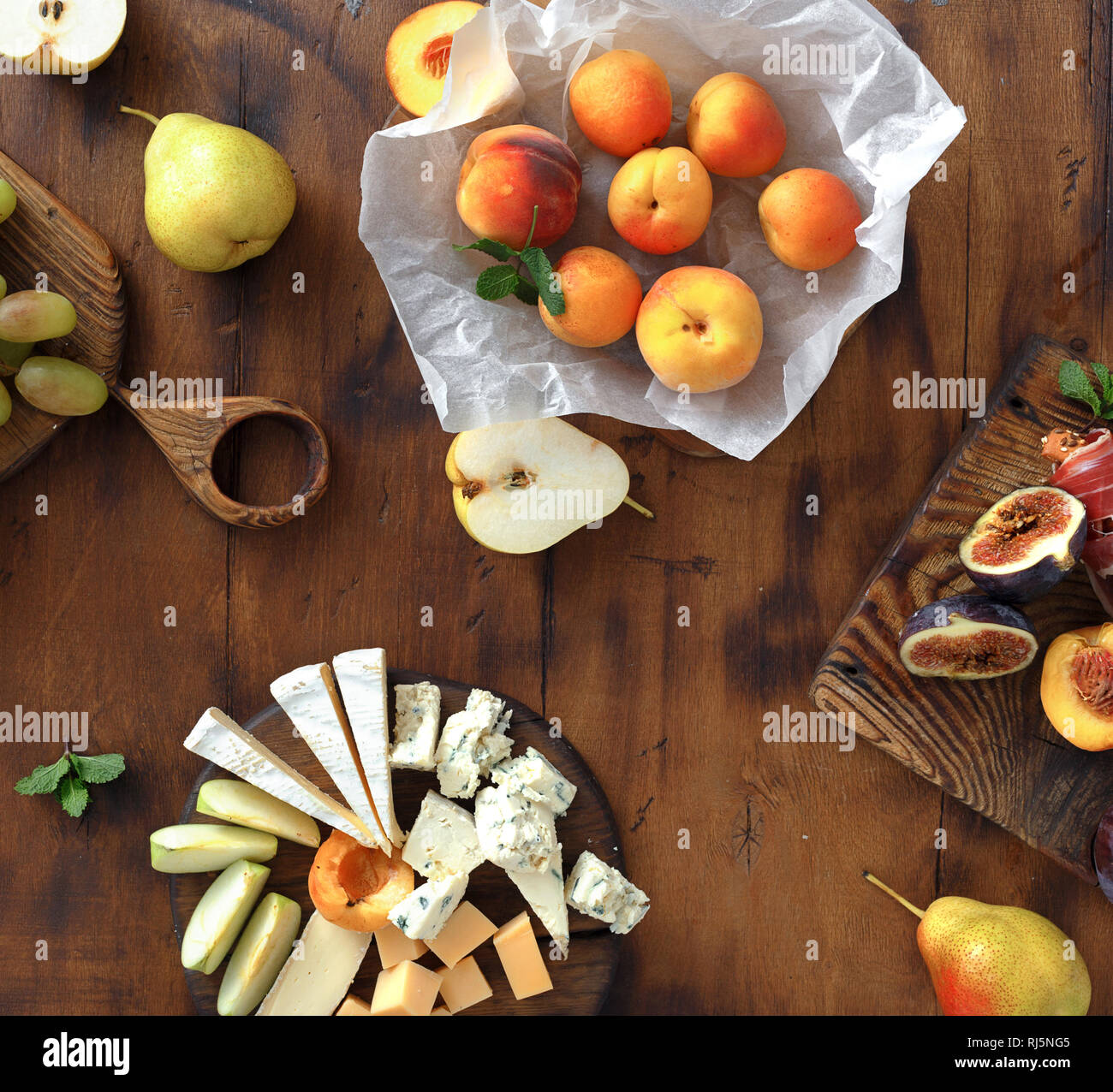 Vorspeisen Tabelle für den Wein. Verschiedene Wein Snacks: Trauben, Pfirsich, Aprikose, Birne, Apfel, jamon, Hartkäse, Brie Käse und Roquefort Käse auf Holz- t Stockfoto