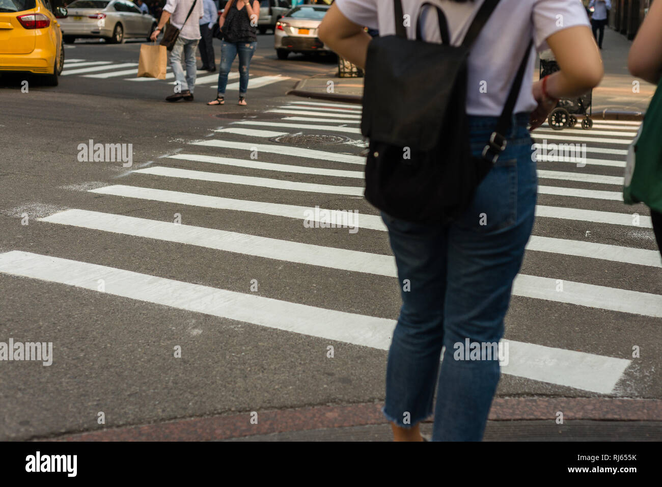 Frau, überqueren Sie die Straße an der Kreuzung in NEW YORK. Stockfoto