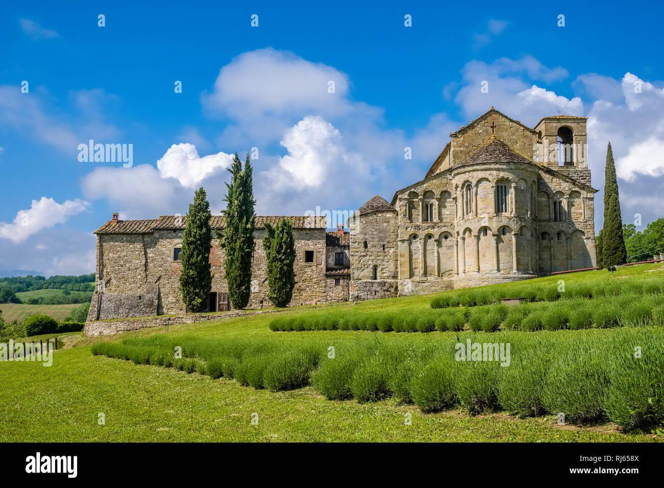 Typische hügelige toskanische Landschaft mit Feldern, Zypressen und der Kirche Pieve di San Pietro ein Romena Stockfoto