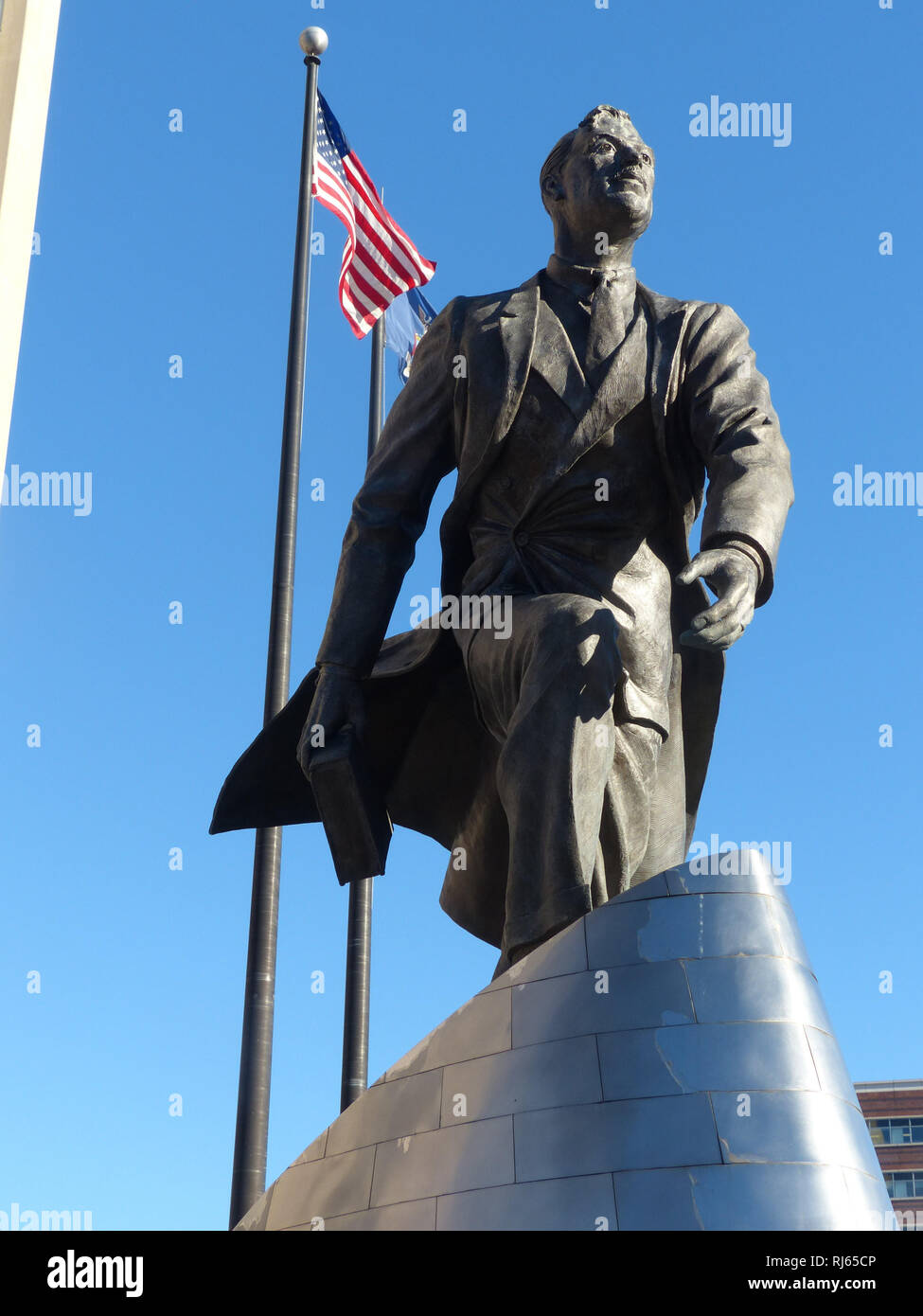 New York Battery Park, Statue von Mann mit US-Flagge bei Marchant Marines Memorial Stockfoto