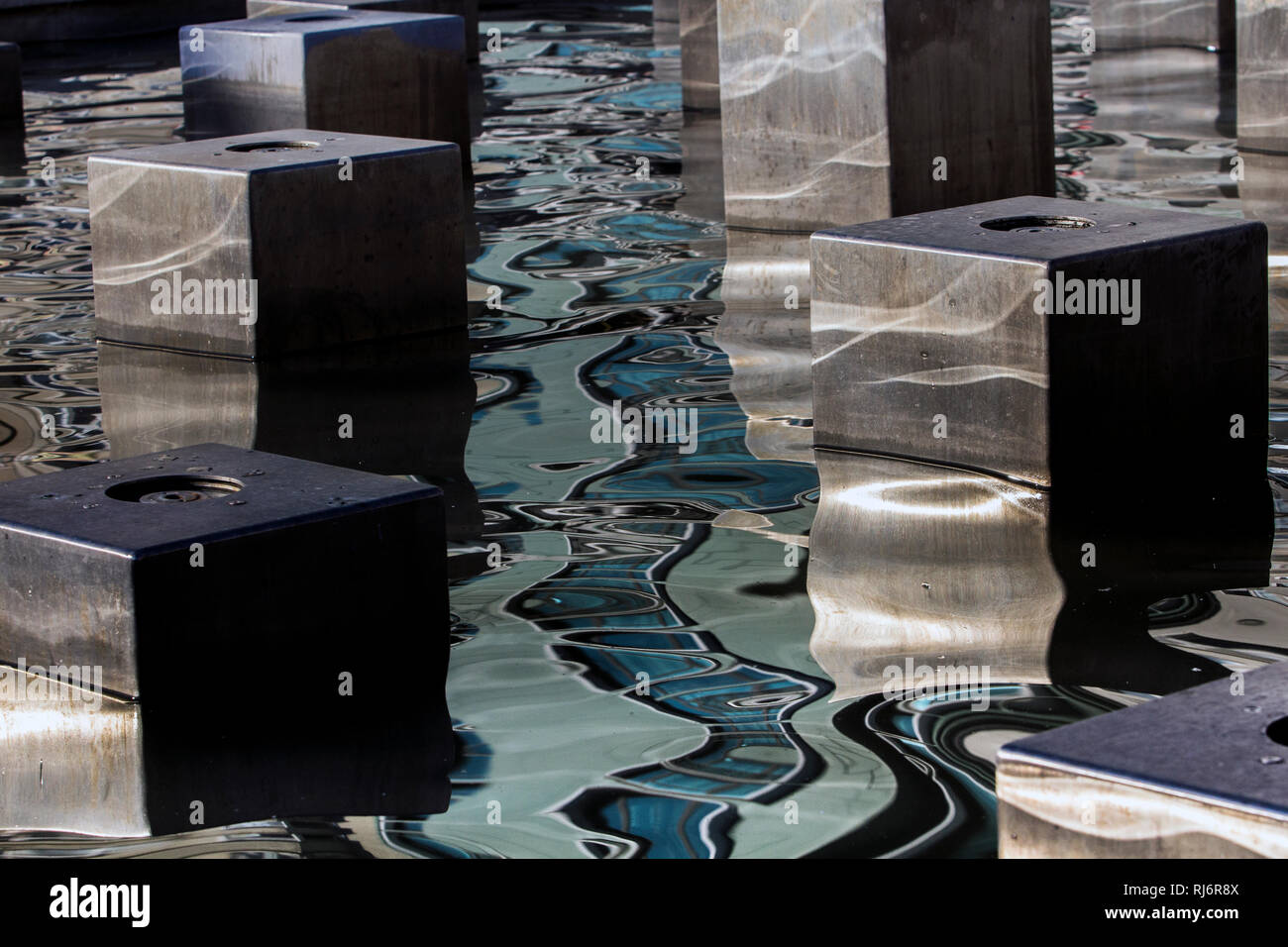 Reflexion der Gebäude auf dem Wasser mit kubischen Elementen aus Stahl Stockfoto