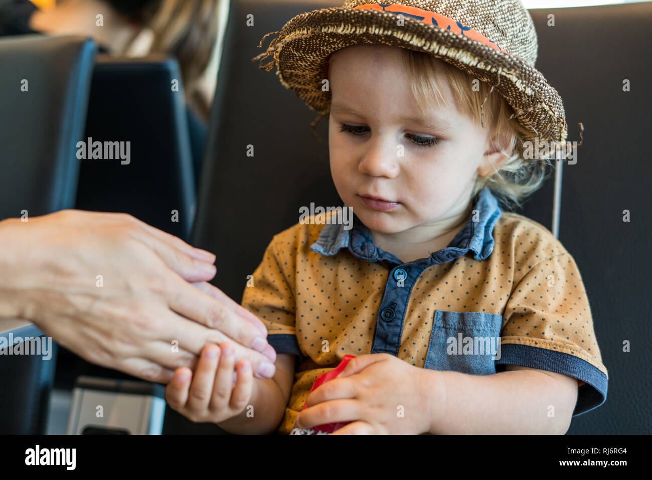 Das Porträt einer jungen 2 jähriger Junge seiner Mutter Hand. Stockfoto