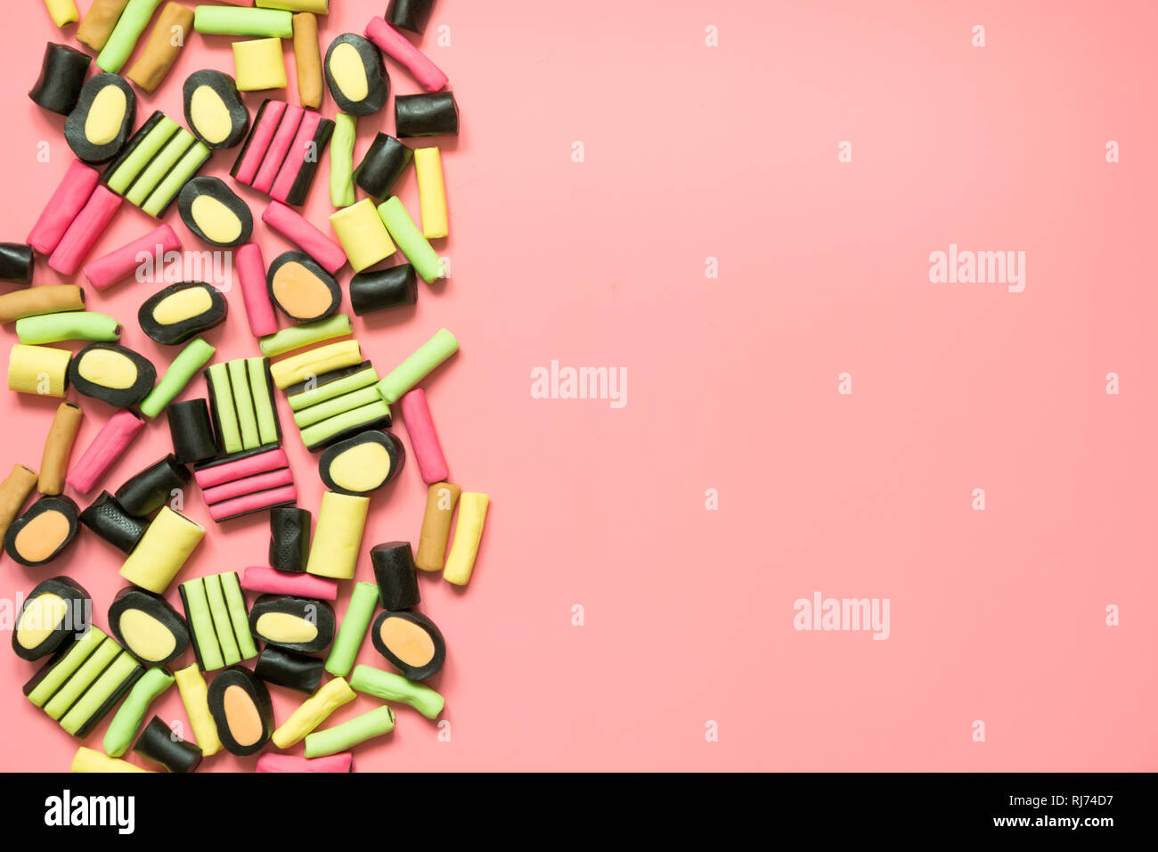 Bunte lollipop und Lakritz Süßigkeiten auf Rosa. Blick von oben. Konzept Banner für Design. Flach. Stockfoto