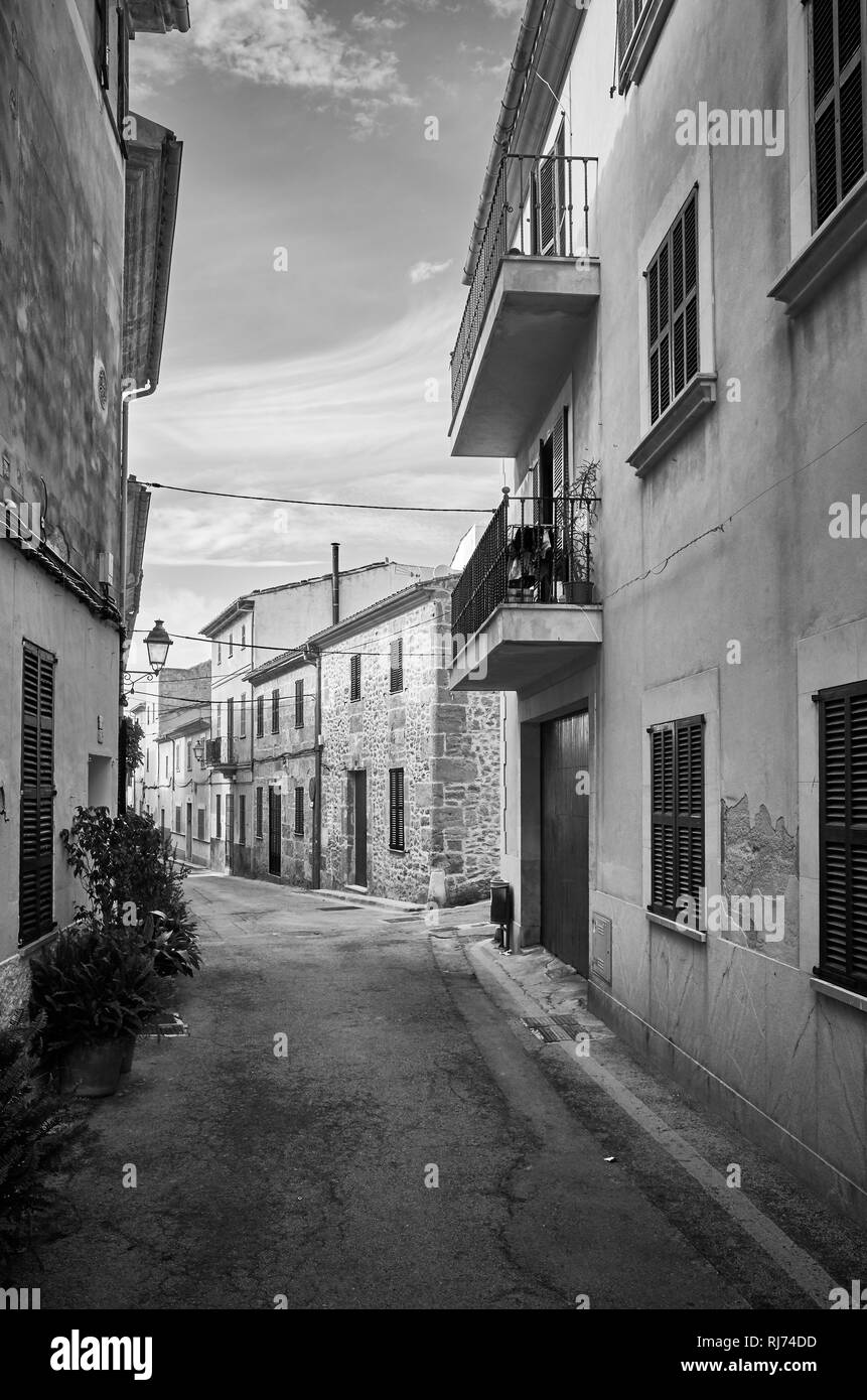 Schwarz-weiß Bild von einer engen Straße in der Altstadt von Alcudia, Mallorca, Spanien. Stockfoto