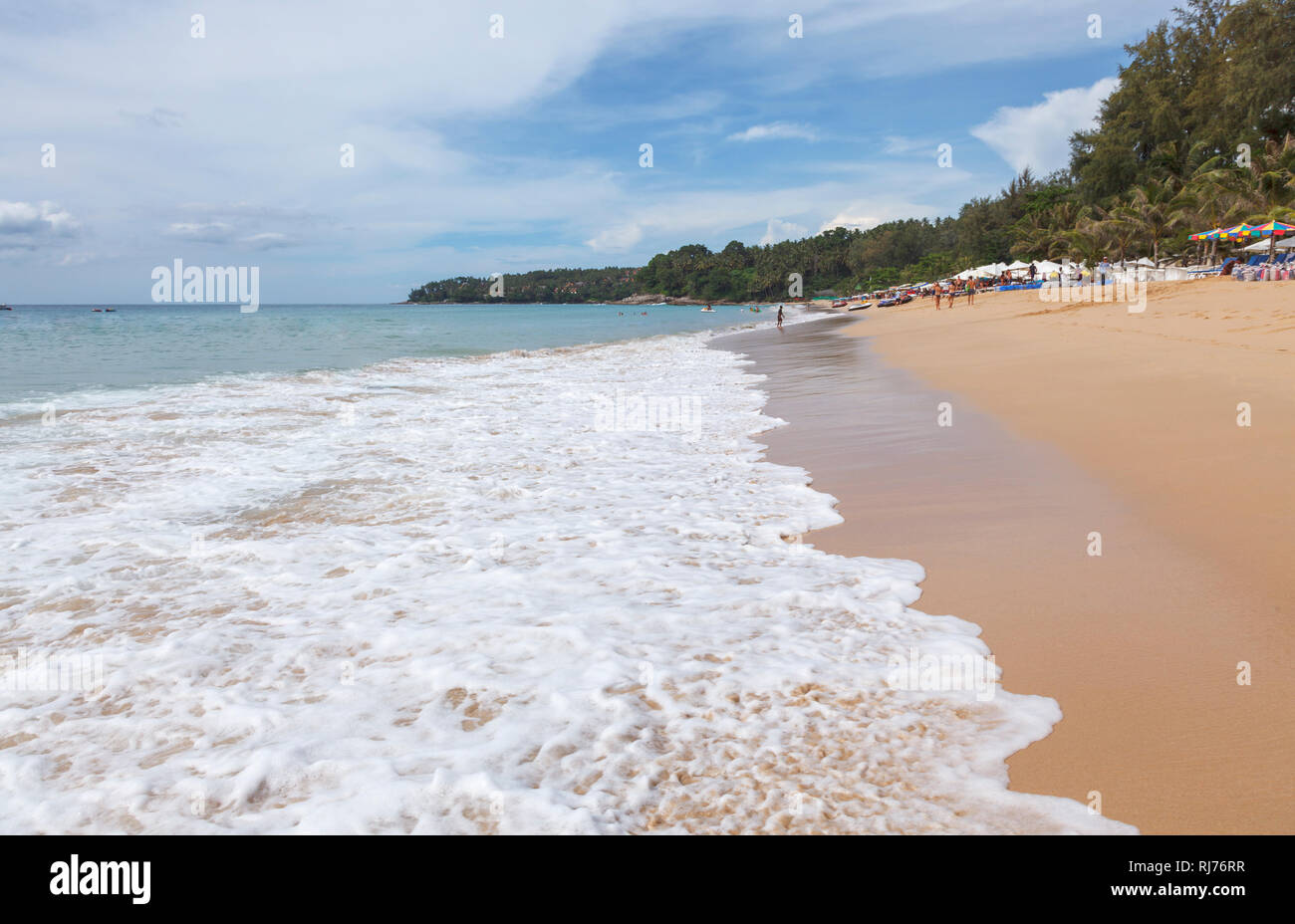 Brechenden Wellen am Strand der Sandstrand von tropischen Palmen gesäumten Strand von Surin, Westküste von Phuket, Thailand Stockfoto