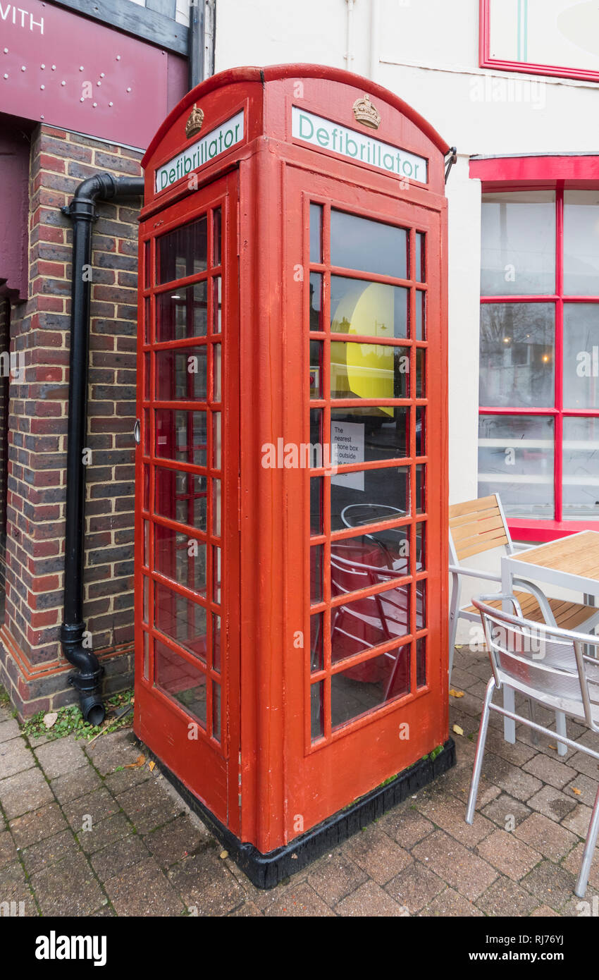 Public Access Defibrillator Maschine in einem alten roten Telefonzelle in Storrington, West Sussex, England, UK. Stockfoto