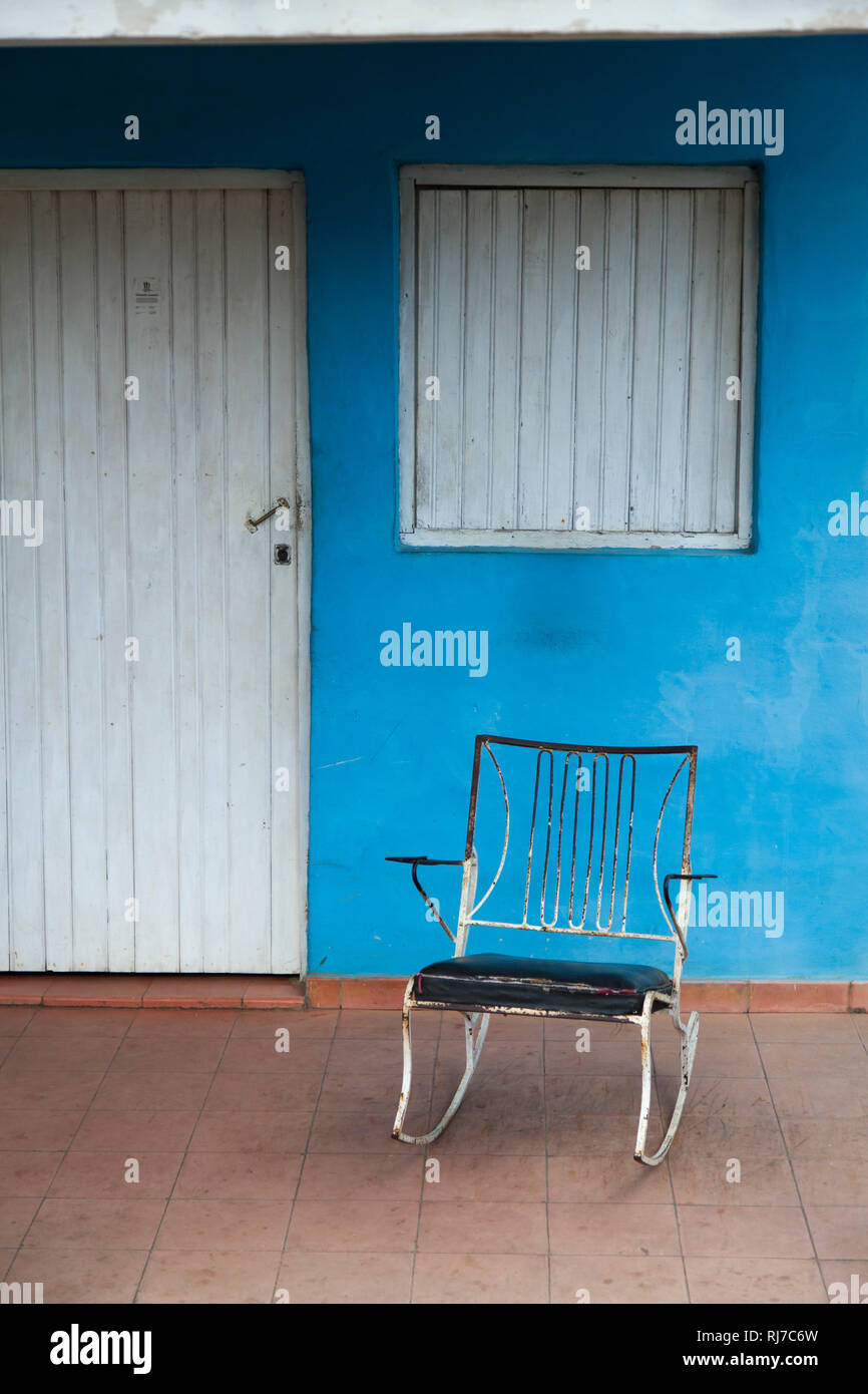 Karibik, Kuba, Kuba, Valle de Viñales Viñales, Schaukelstuhl vor blauer Hauswand und weißer Tür Stockfoto