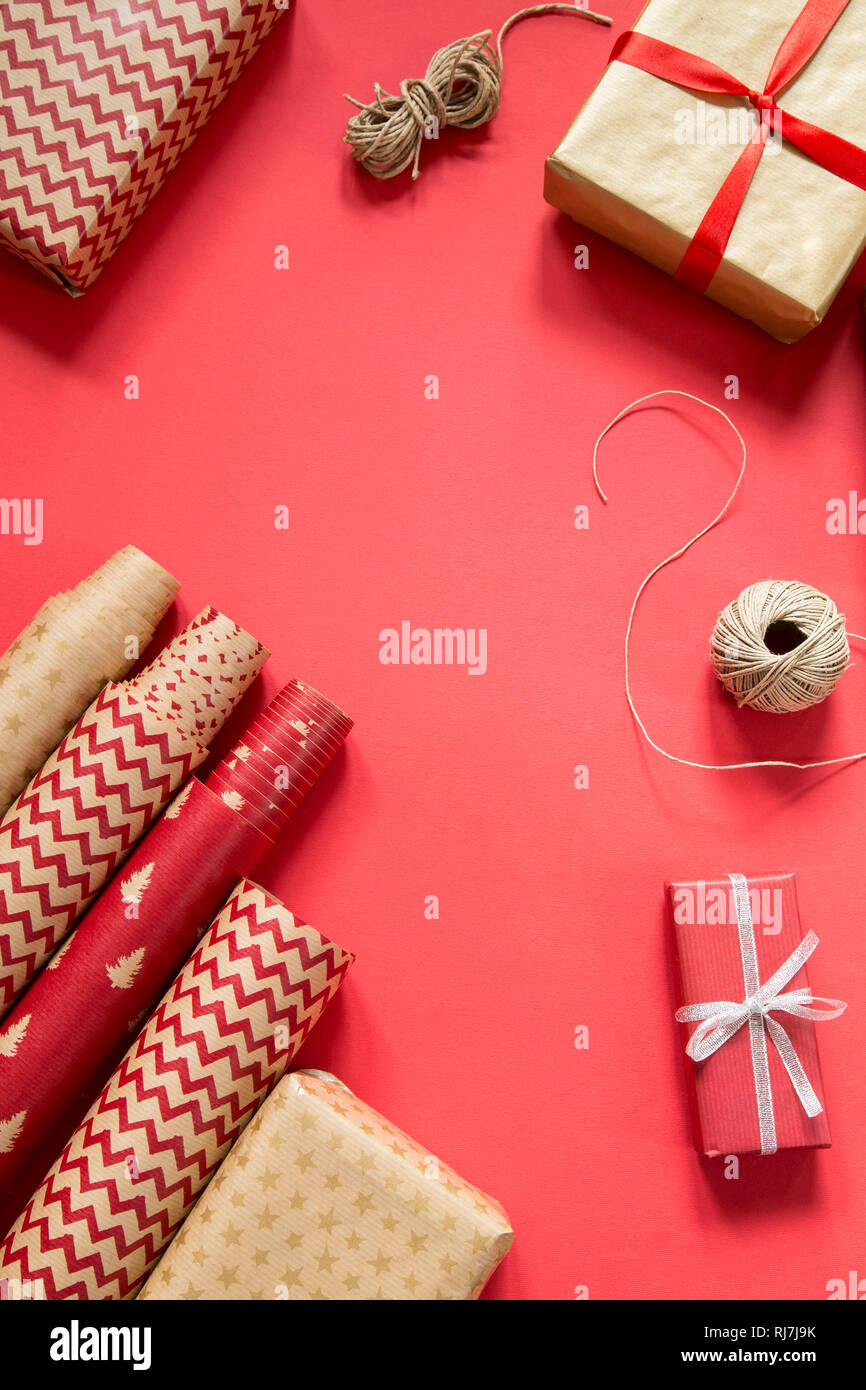 Verpackung Weihnachtsgeschenke auf rotem Papier Hintergrund Stockfoto