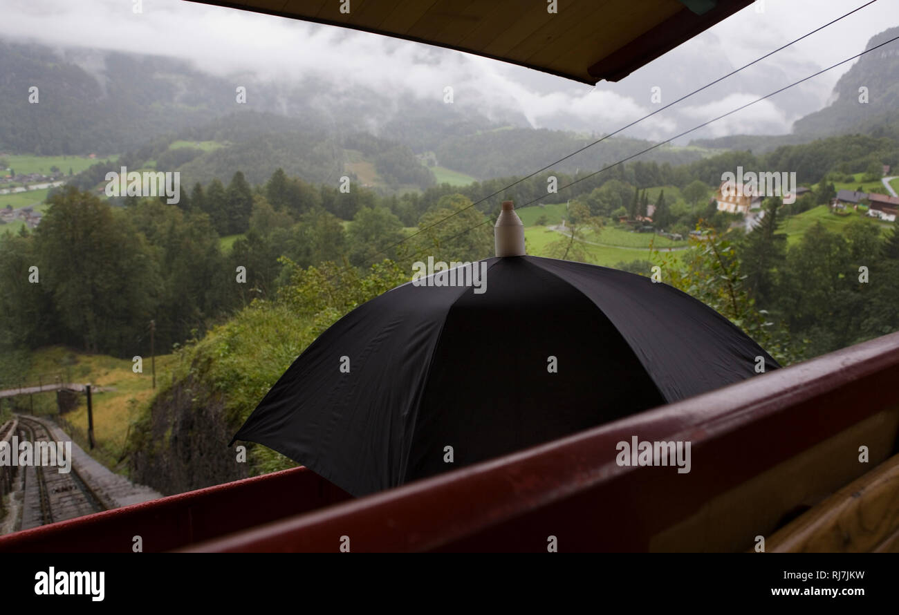 An Bord der Reichenbachfall-Bahn, aka RfB (in Englisch die Richenbach fällt  Railway), Meiringen: Der Motor Treiber verwendet einen Regenschirm als  Schild von t Stockfotografie - Alamy