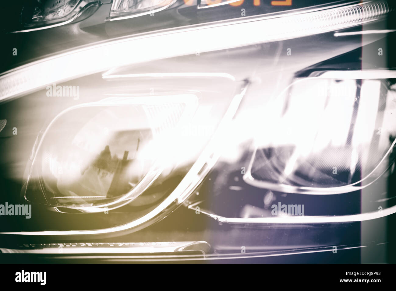 Nahaufnahme des Frontlichtes eines Kraftfahrzeuges mit Neonscheinwerfern. Stockfoto