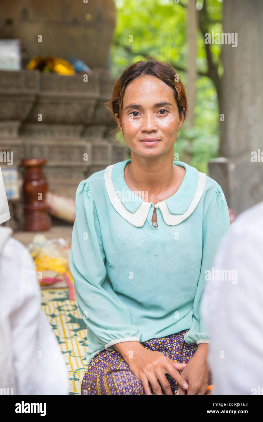 Siem Reap, Angkor Baphuon, Tempel, eine Frau sterben, vor einer großen Buddhastatue sitzt und für Touristen gegen Geld betet Stockfoto