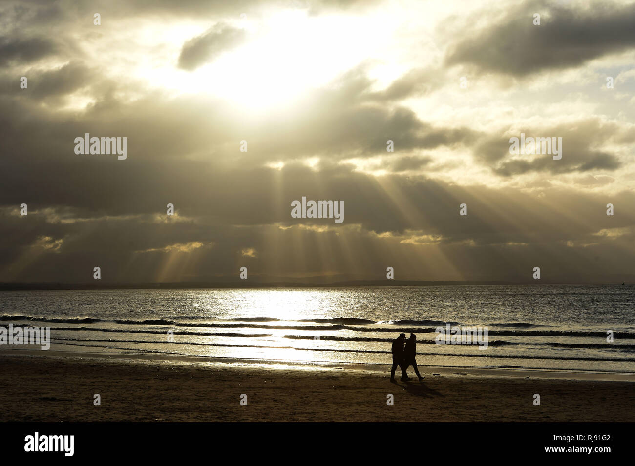 Strahlen der Sonne Auf Spaziergänger am Strand von Crosby. 6. Januar 2018. Stockfoto