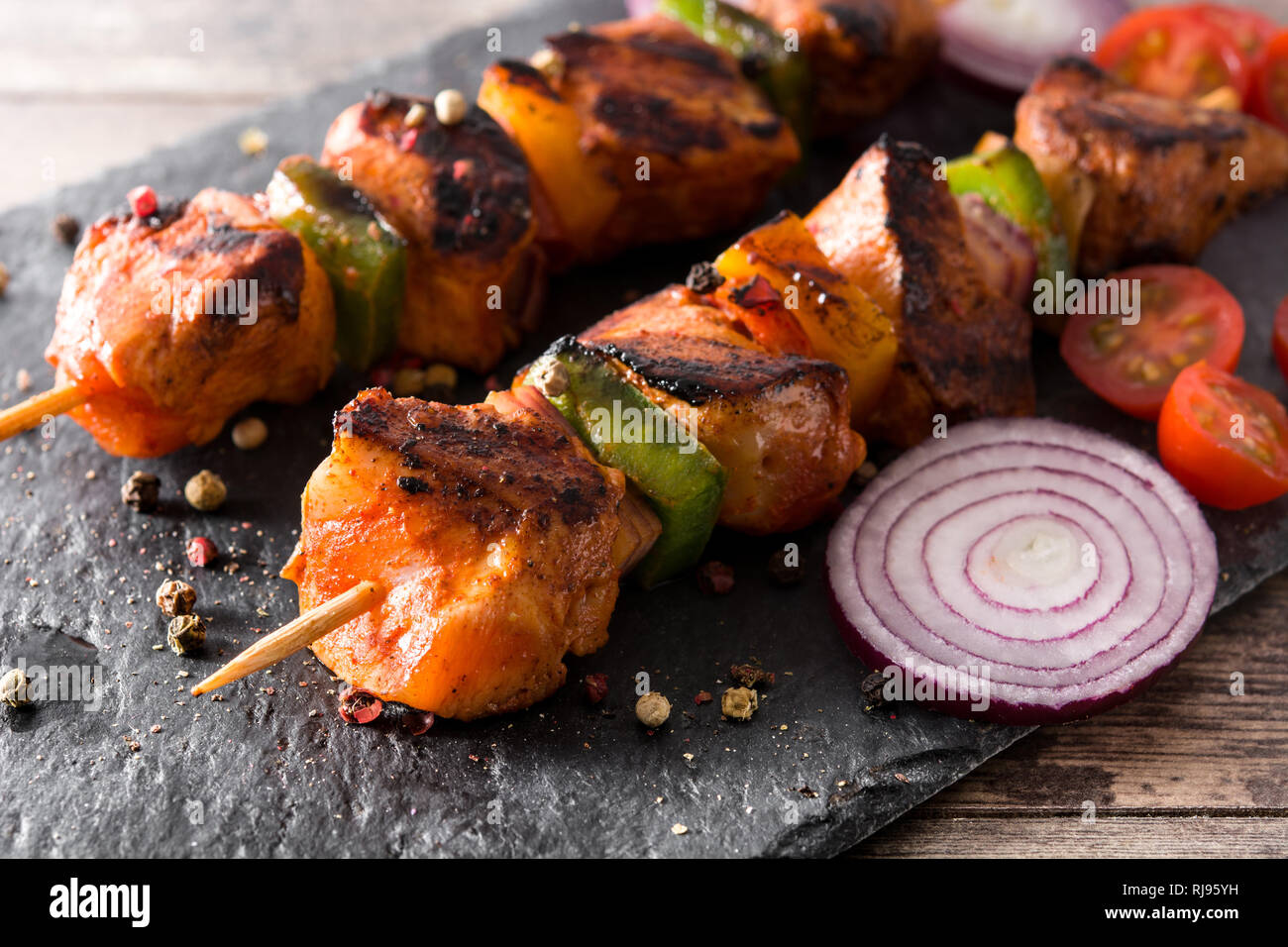 Hühnchen Shish Kebab mit Gemüse auf schwarzen Stein Stockfoto