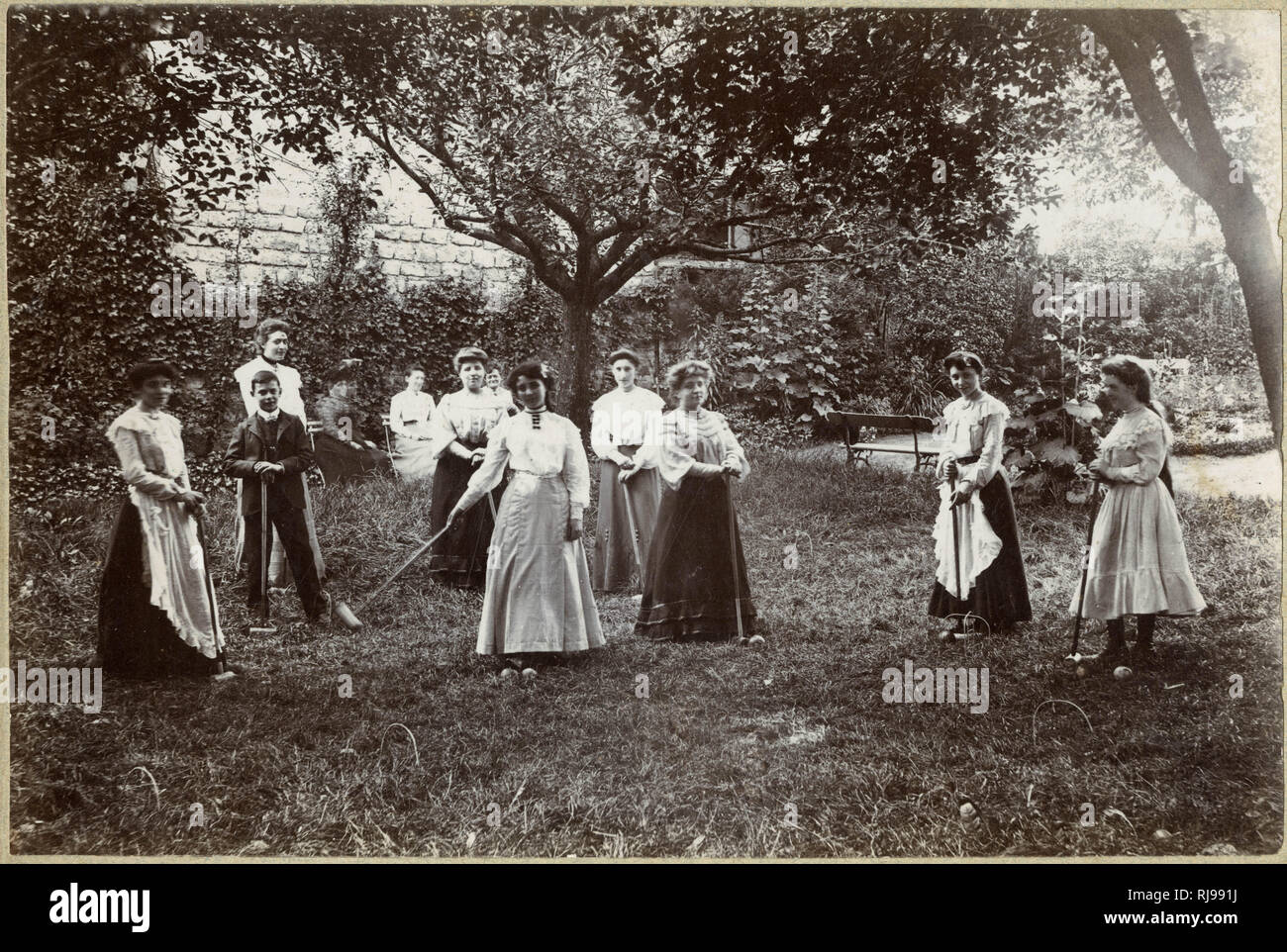 Eine große Gruppe von Frauen spielen Krocket auf eine grobe - Suchen Tonhöhe. Stockfoto