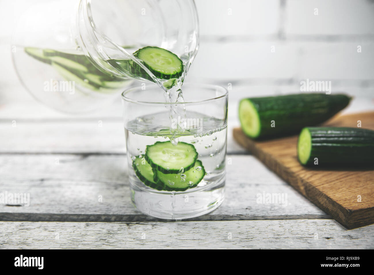 Detox drink - frische Gurke Wasser in ein Glas gießen Stockfoto