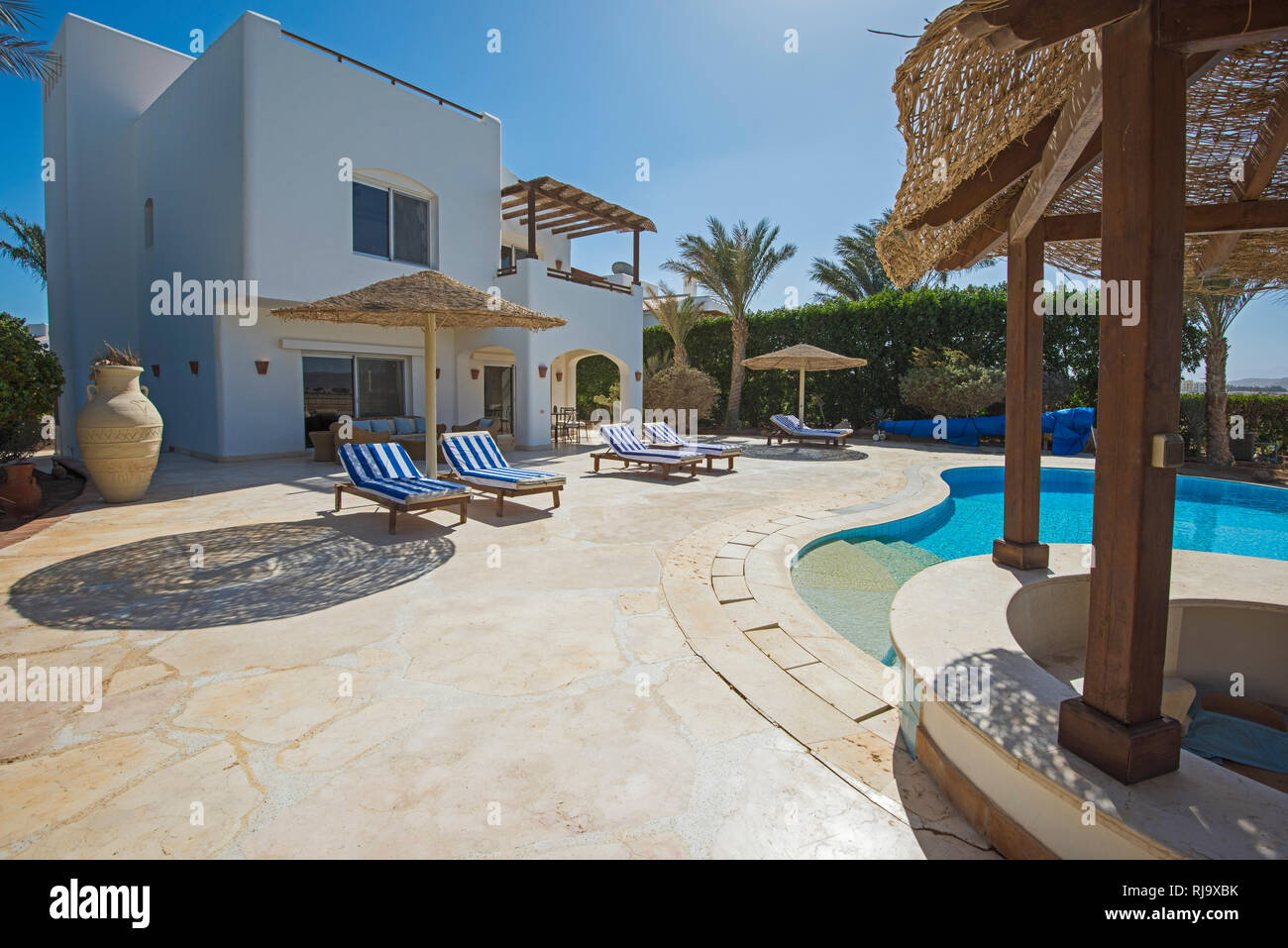 Luxus Villa zeigen Home im tropischen Sommer Holiday Resort mit Swimmingpool und Liegestühlen Stockfoto
