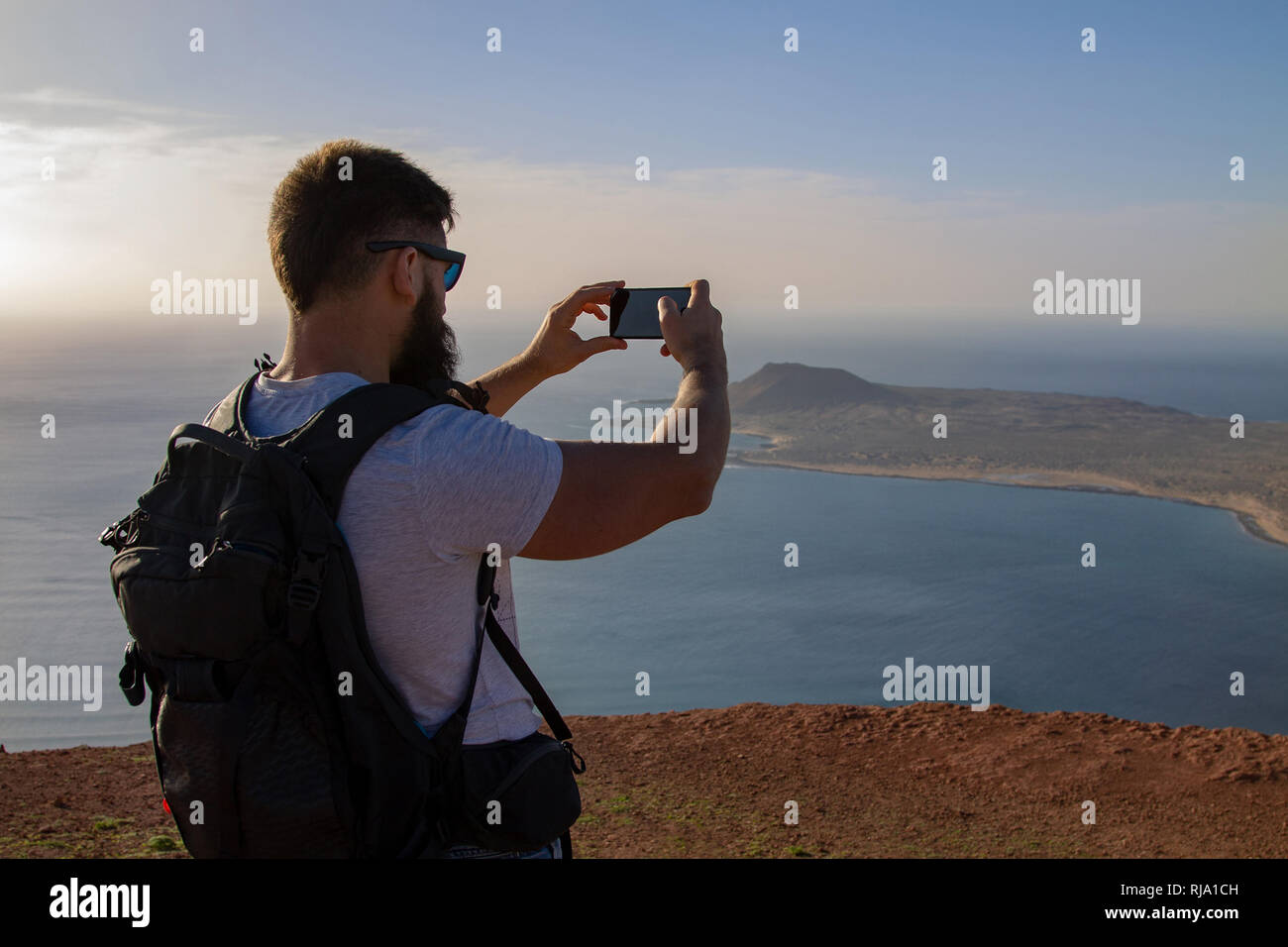 Der Mann Fotografien auf einer Insel im Ozean, stehen am Rand einer Klippe. Mirador del Rio, Lanzarote, Spanien. Stockfoto