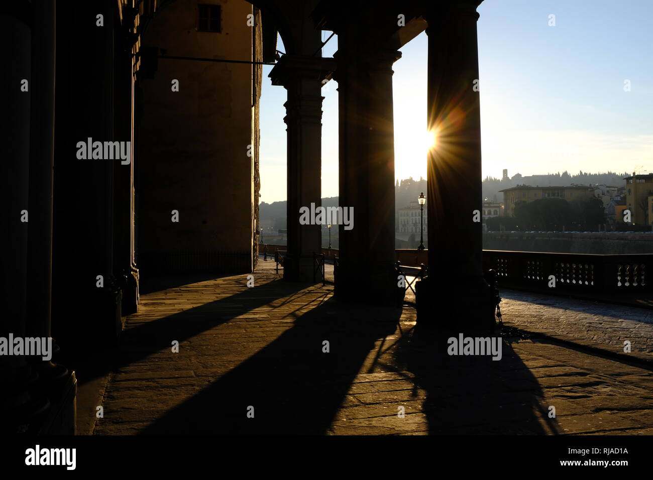 Am frühen Morgen Sonnenlicht wirft lange Schatten durch die Spalten der Eintritt in die Uffizien am Ufer des Flusses Arno in Florenz Italien Stockfoto