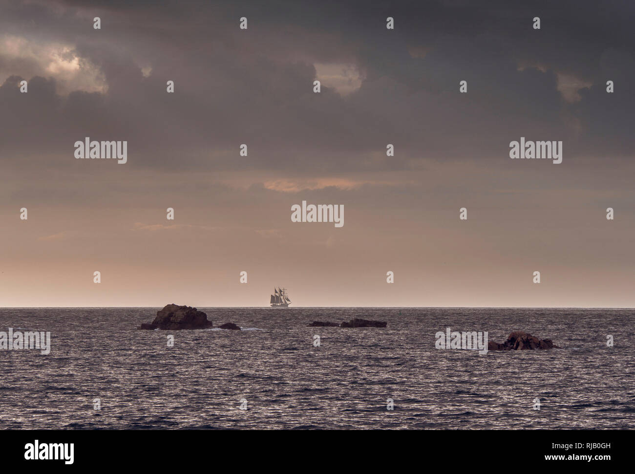 Altes Segelschiff im Abendlicht am Horizont, Blick von Pleubian, Bretagne Stockfoto