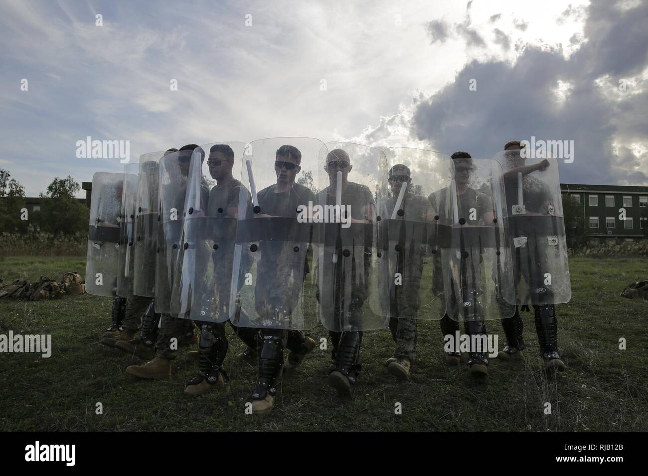 Marines mit Special Purpose Marine Air-Ground Task Force Krise Response-Africa einen Keil Formation mit Riot Shields während nicht-tödliche Ausbildung bei Naval Air Station Sigonella, Italien, November 3, 2016. Marines abgeschlossen eine Woche nicht-tödlichen Verlauf, der Taser Ausbildung, OC Belichtung und riot control Team Taktik. Stockfoto