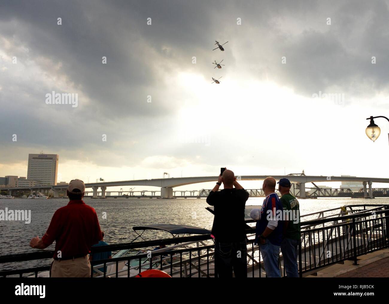 JACKSONVILLE, Fla (4. November 2016) - Zuschauer nehmen Sie Fotos als drei MH-60R multi-mission Hubschrauber, der stolze Krieger der Hubschrauber Maritime Strike Geschwader sieben Zwei zugewiesen, eine Fly-over über den St. Johns River in Downtown Jacksonville für eine pep Rally aus der Marine gegen Notre Dame Spiel Wochenende zu treten. Navy ging auf Notre Dame, 28-27 zu schlagen. Stockfoto